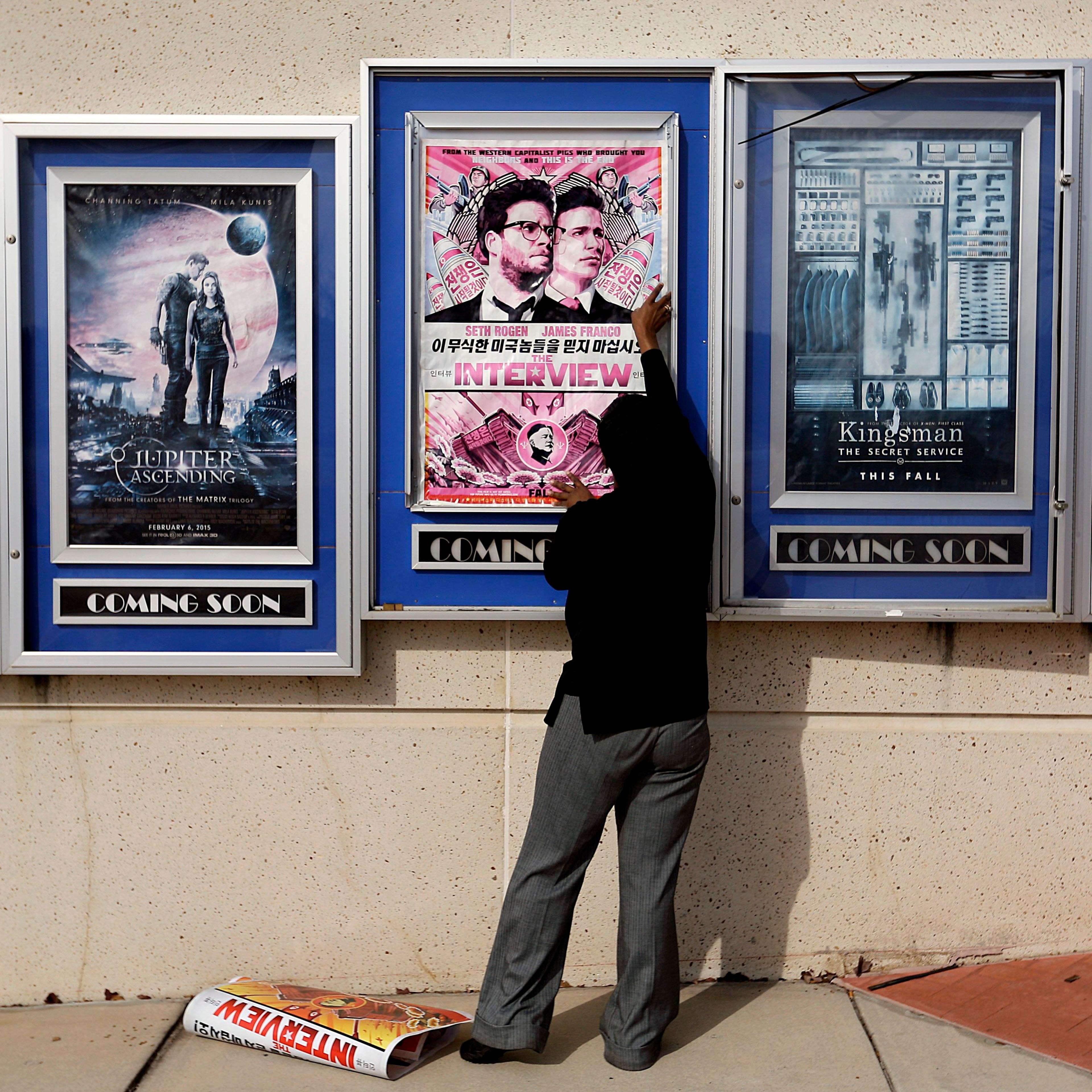 A poster for the movie "The Interview" is taken down by a worker after being pulled from a display case at a Carmike Cinemas movie theater, Wednesday, Dec. 17, 2014, in Atlanta.