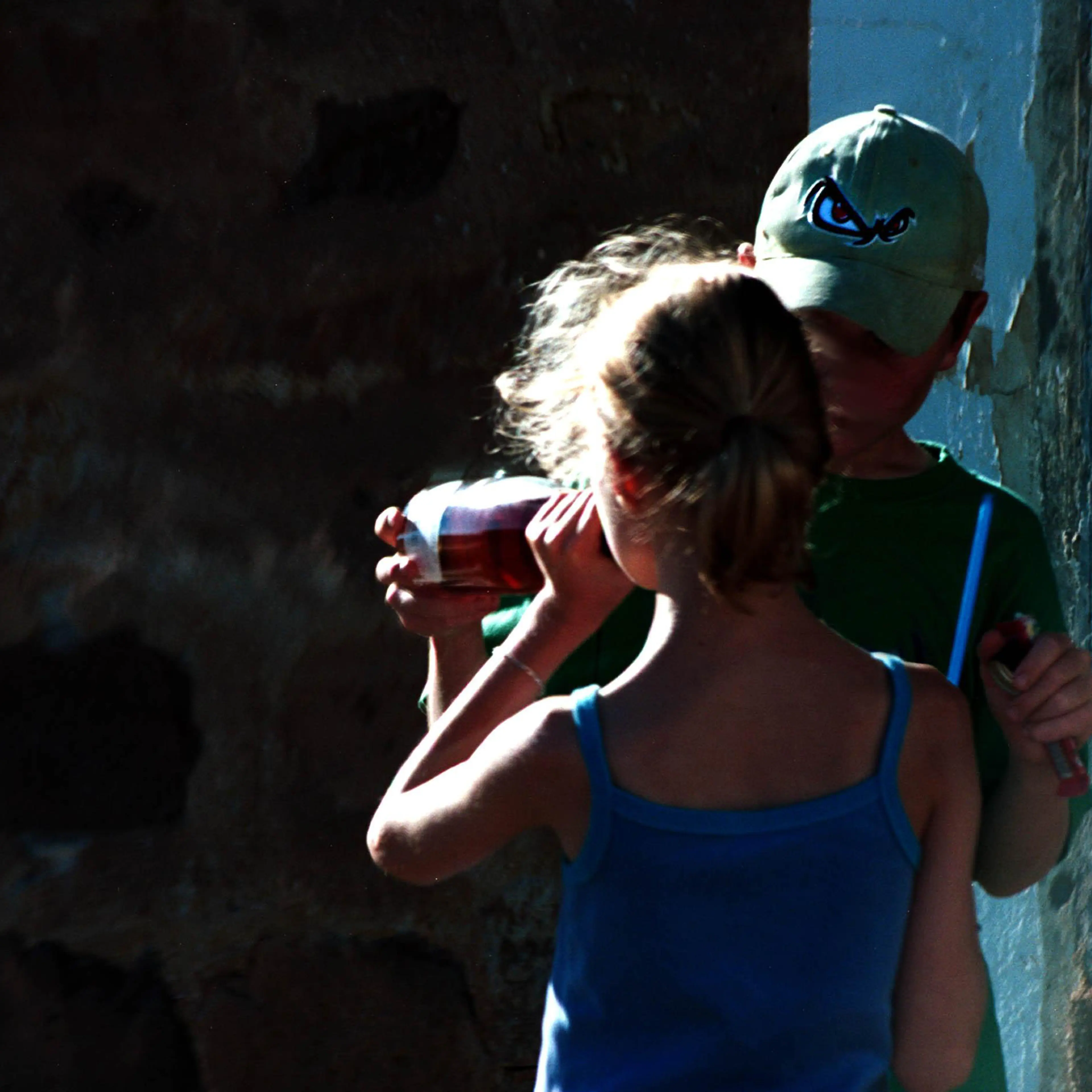 Young boy giving a bottle of wine to a young girl
