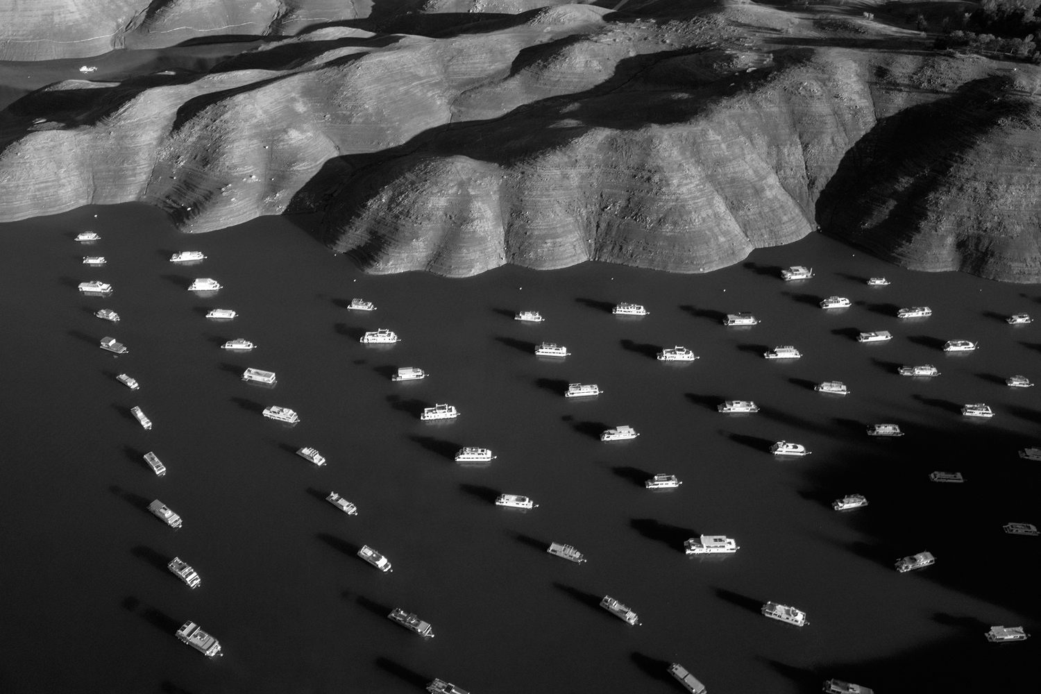 House boats appear next to the shoreline of Bidwell Canyon on Lake Oroville in Northern California on November 25, 2014. Lake Oroville is California's second largest reservoir, and is currently 70% empty as a result of the state's severe drought.