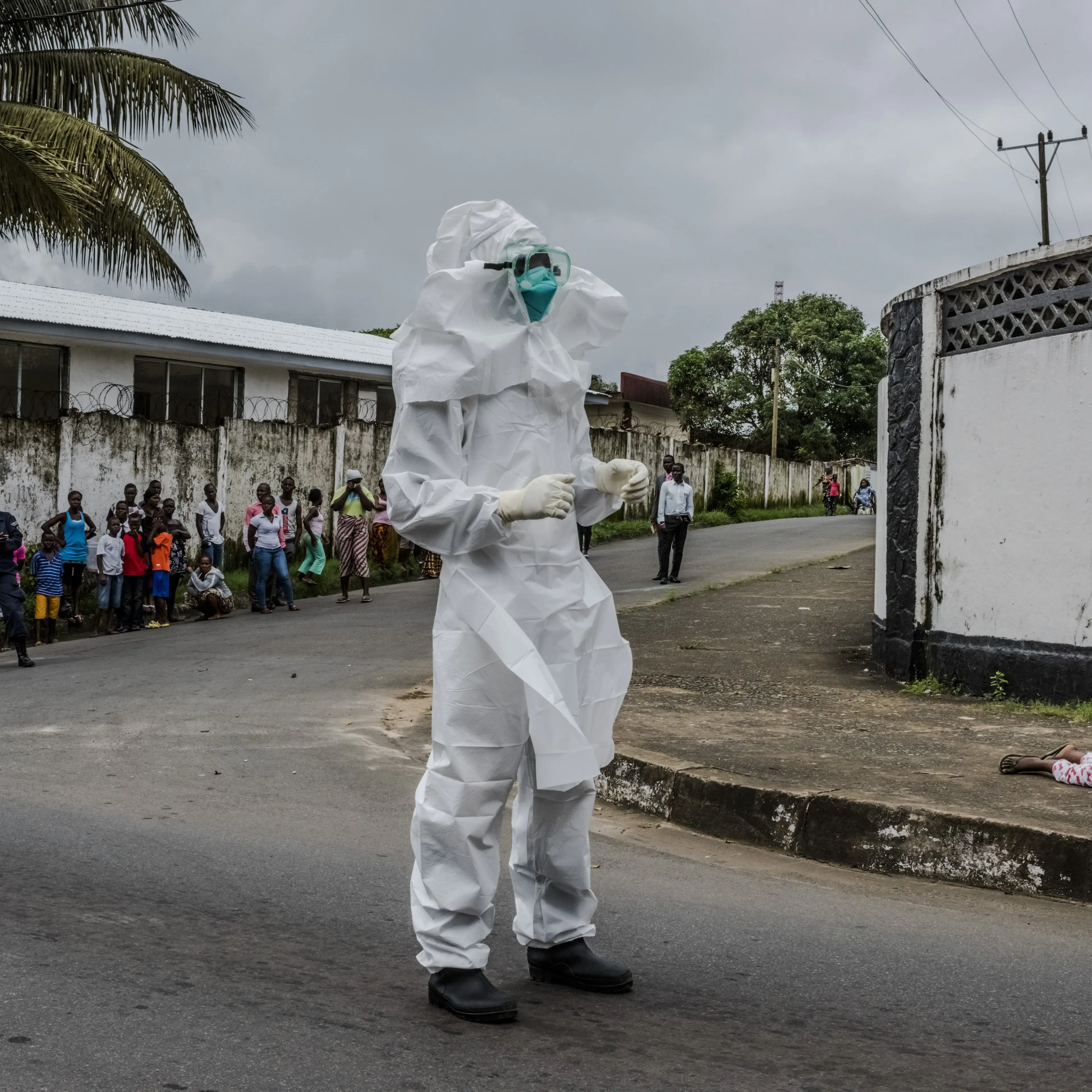 A girl suspected of having Ebola lies on a sidewalk, where her aunt left her after she was unable to get help, in Monrovia, Liberia, Aug. 31, 2014.