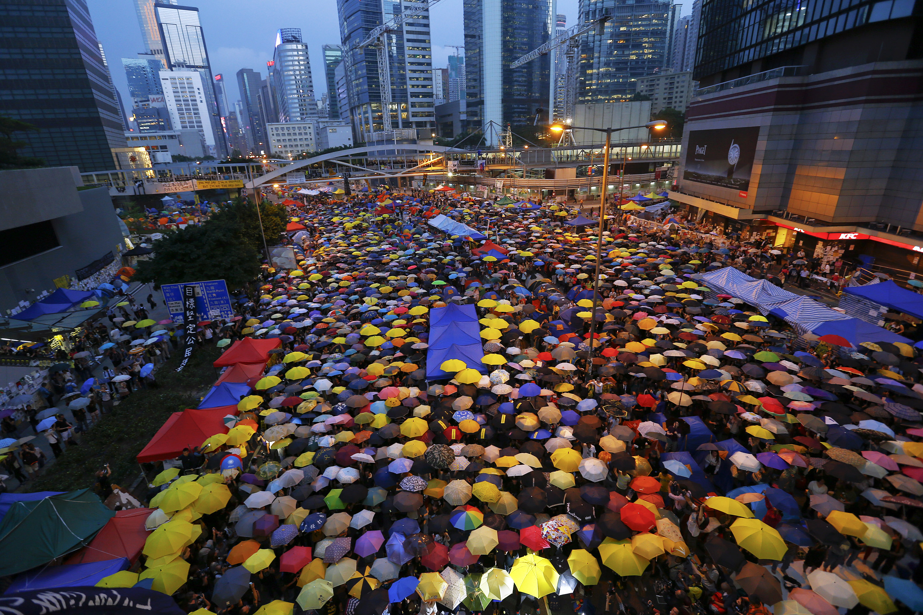 Protesters open their umbrellas, symbols of pro-democracy movement, as they mark exactly one month since they took the streets in Hong Kong's financial central district