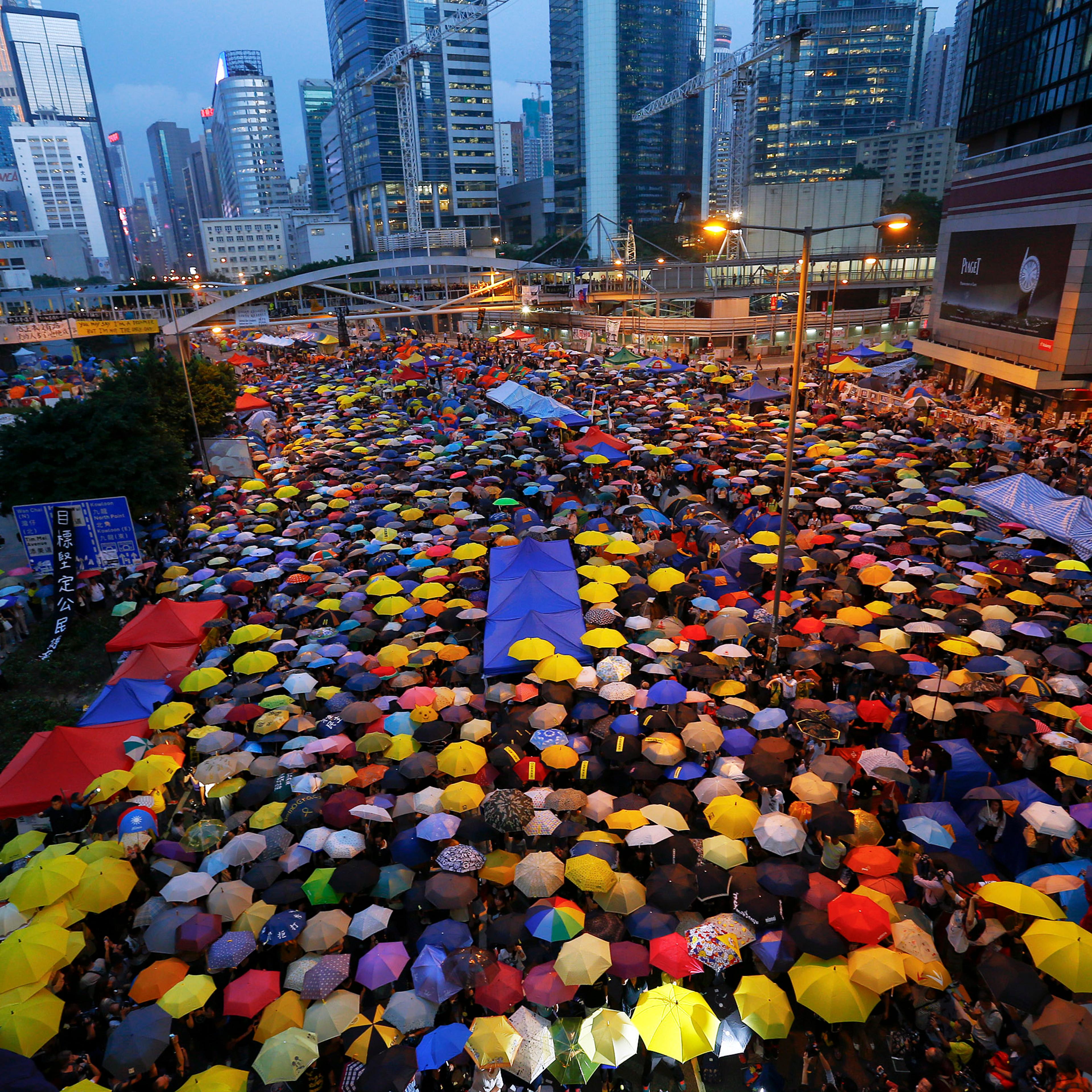 Protesters open their umbrellas, symbols of pro-democracy movement, as they mark exactly one month since they took the streets in Hong Kong's financial central district