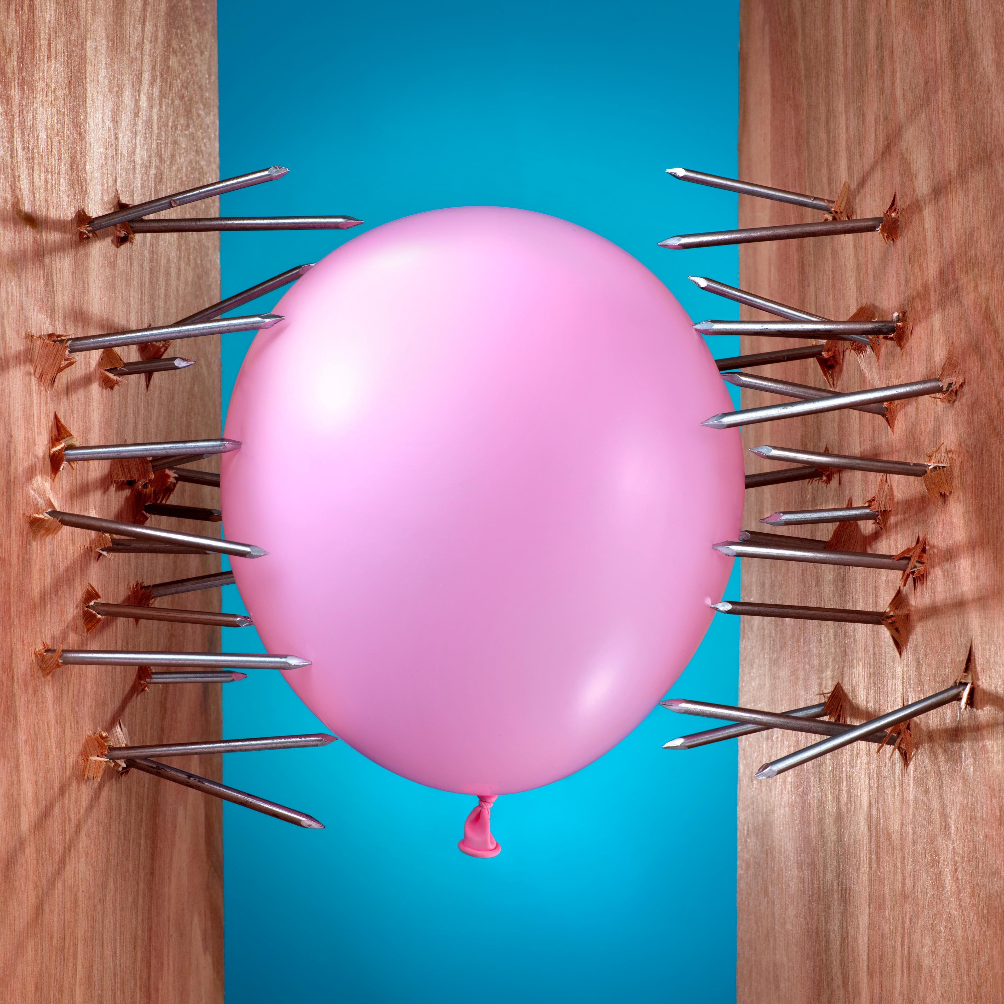 Pink balloon between two sets of nails