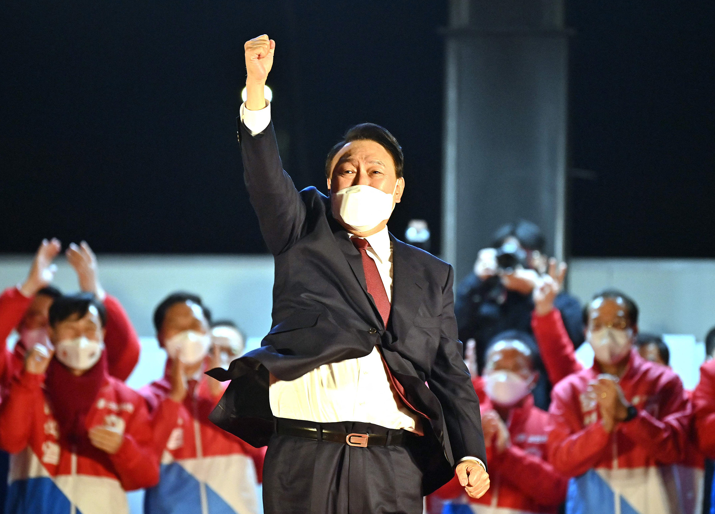 South Korea's new president-elect Yoon Suk Yeol, of the People Power Party, gestures to his supporters as he is congratulated outside the party headquarters in Seoul on March 10, 2022.