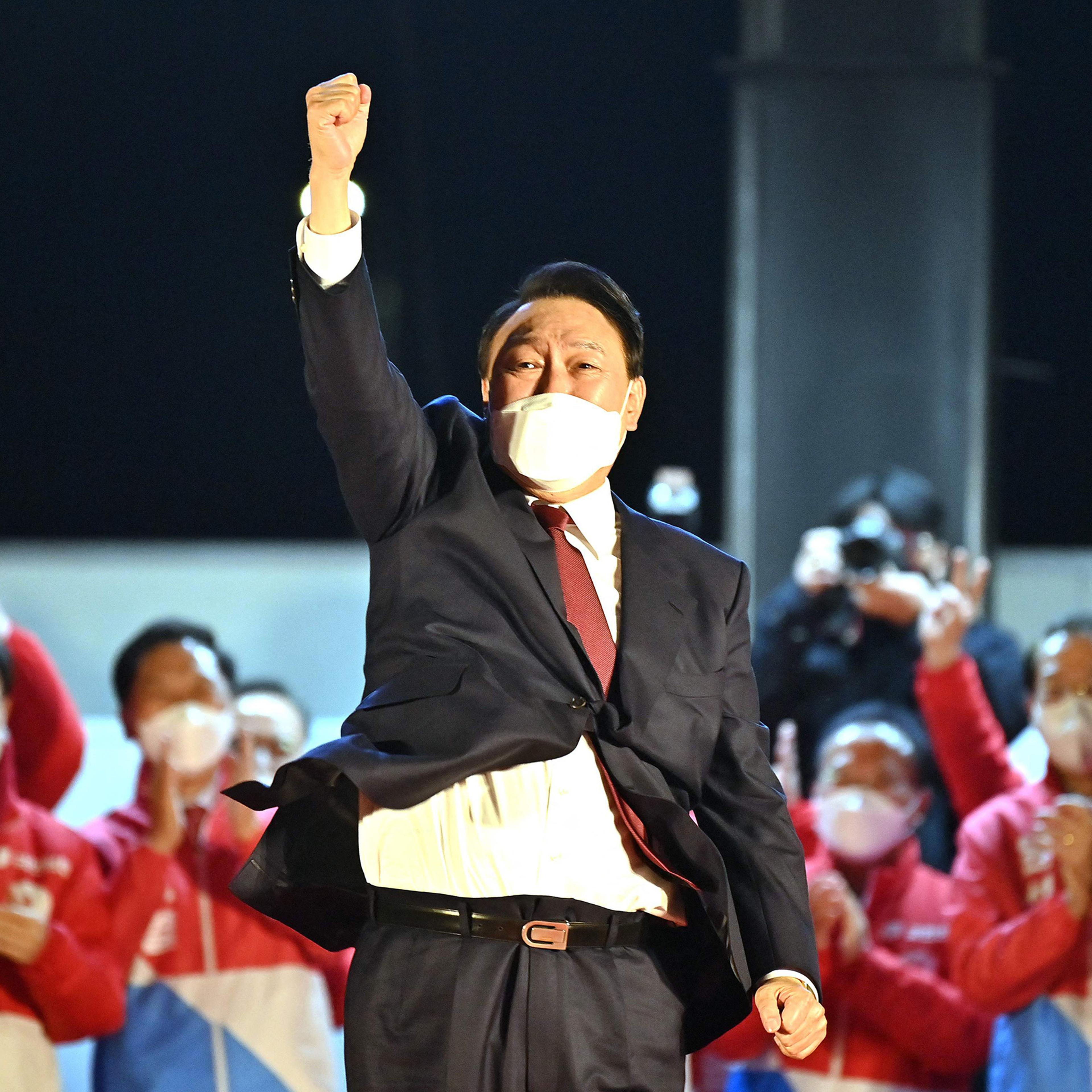 South Korea's new president-elect Yoon Suk Yeol, of the People Power Party, gestures to his supporters as he is congratulated outside the party headquarters in Seoul on March 10, 2022.