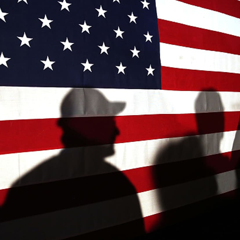 Shadows are reflected on an American Flag as people line up to speak with Ohio Governor and Republican presidential candidate John Kasich at a restaurant in South Carolina following his second place showing in the New Hampshire primary on February 11, 20