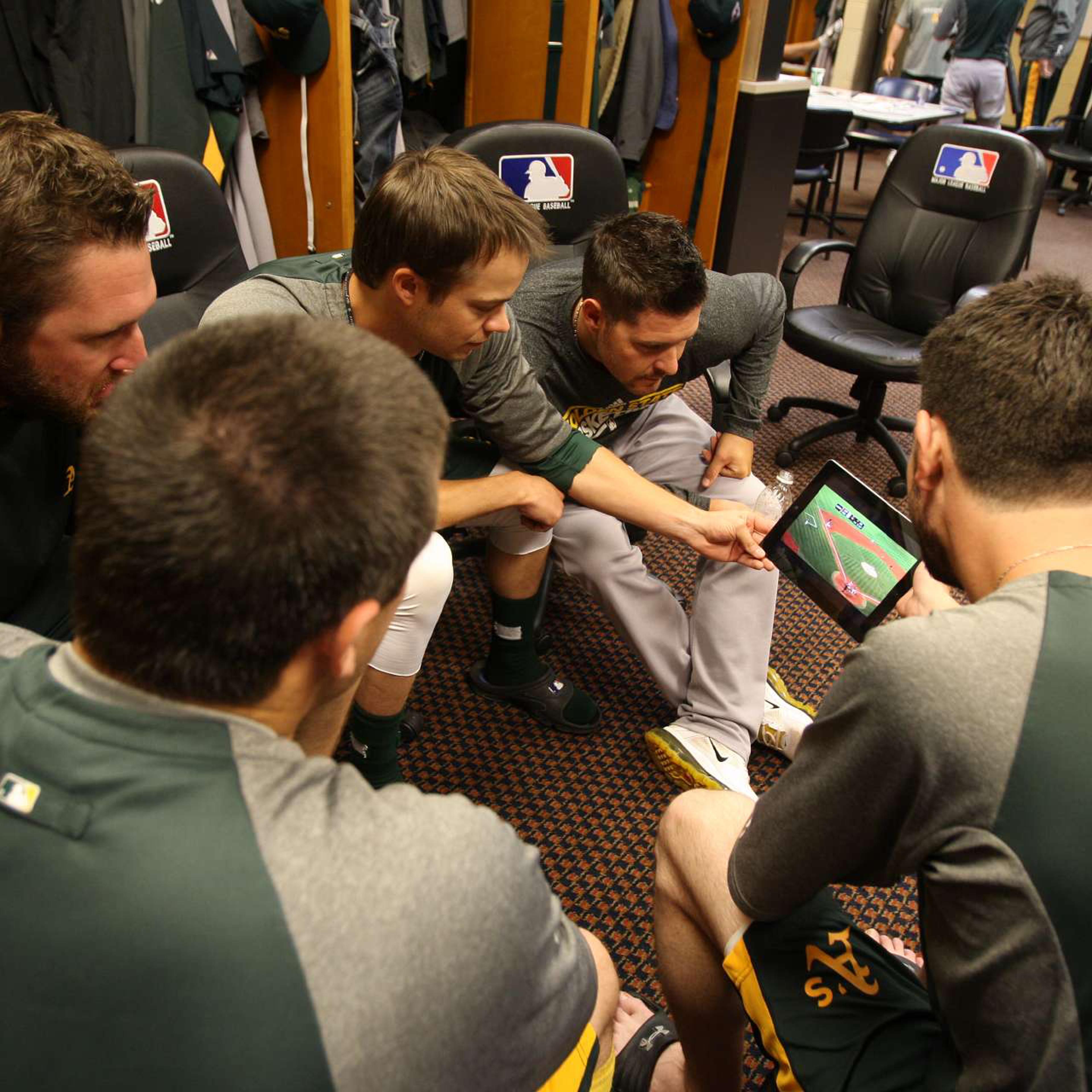 Members of the Oakland Athletics pitching staff watch highlights of the Athletics on an iPad in the clubhouse prior to the game against the Detroit Tigers at Comerica Park on October 6, 2012 in Detroit, Michigan.