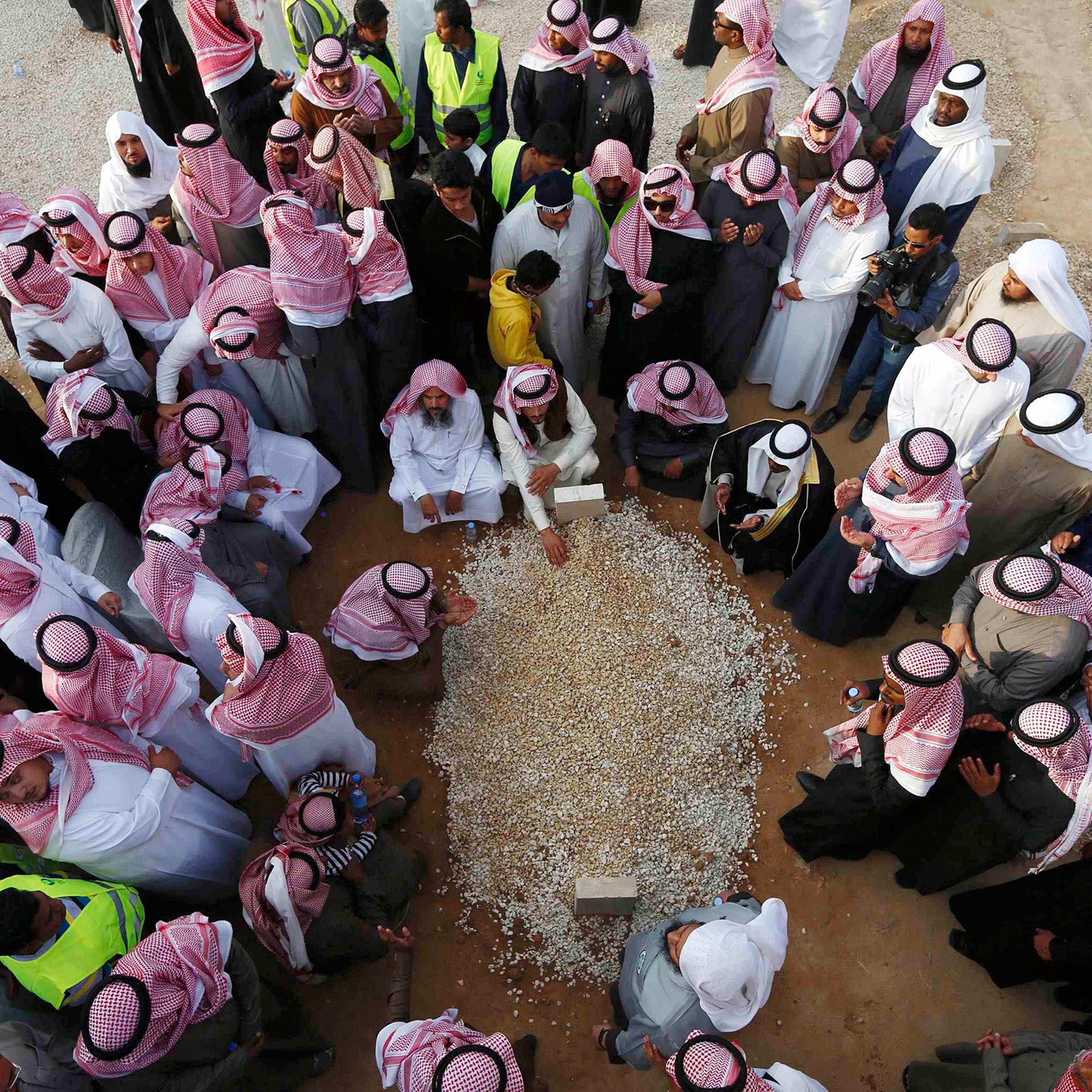 Mourners gather around the grave of Saudi King Abdullah following his burial in Riyadh
