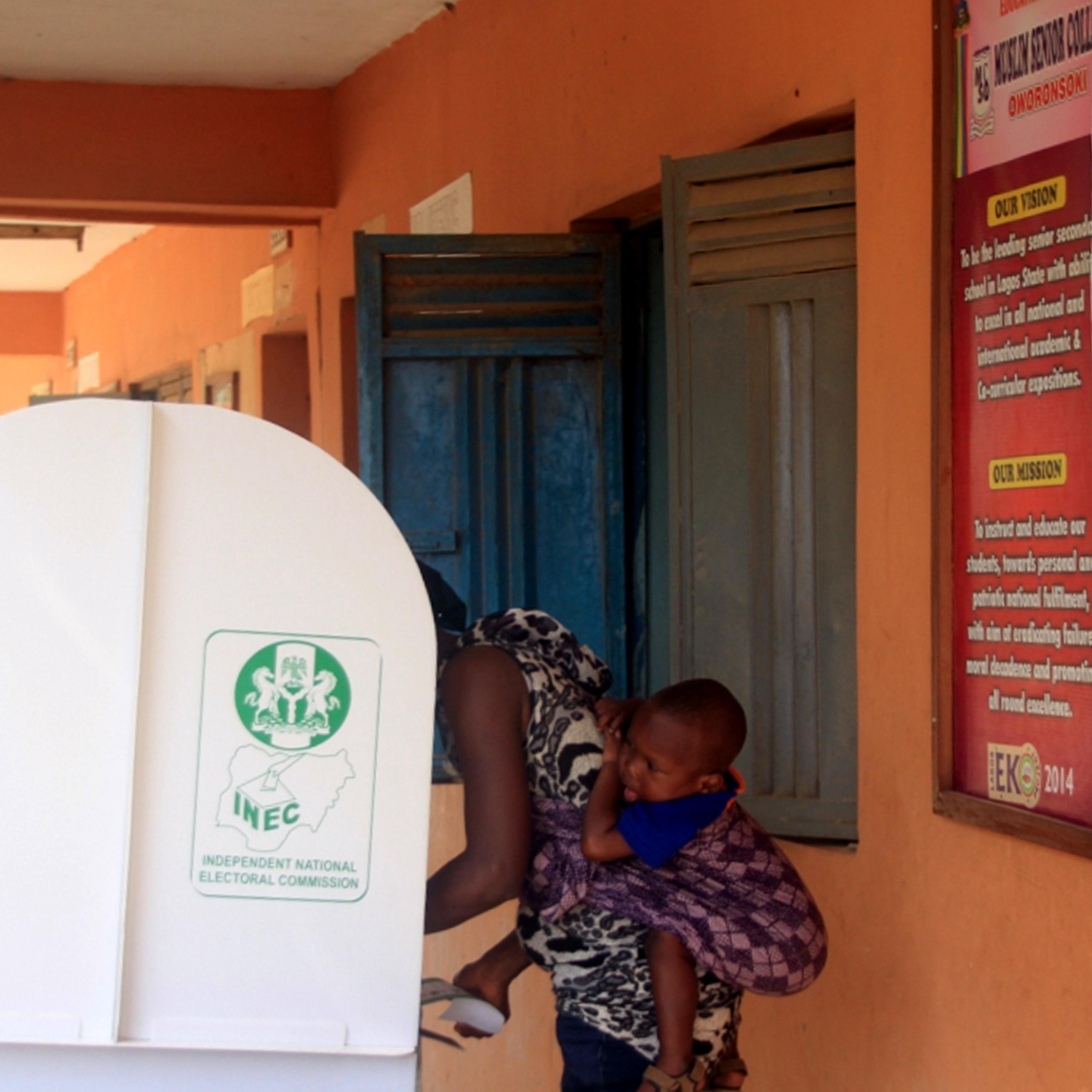 A voter carrying her baby on her back is seen in a polling booth in the city of Lagos, Nigeria on March 29, 2015.