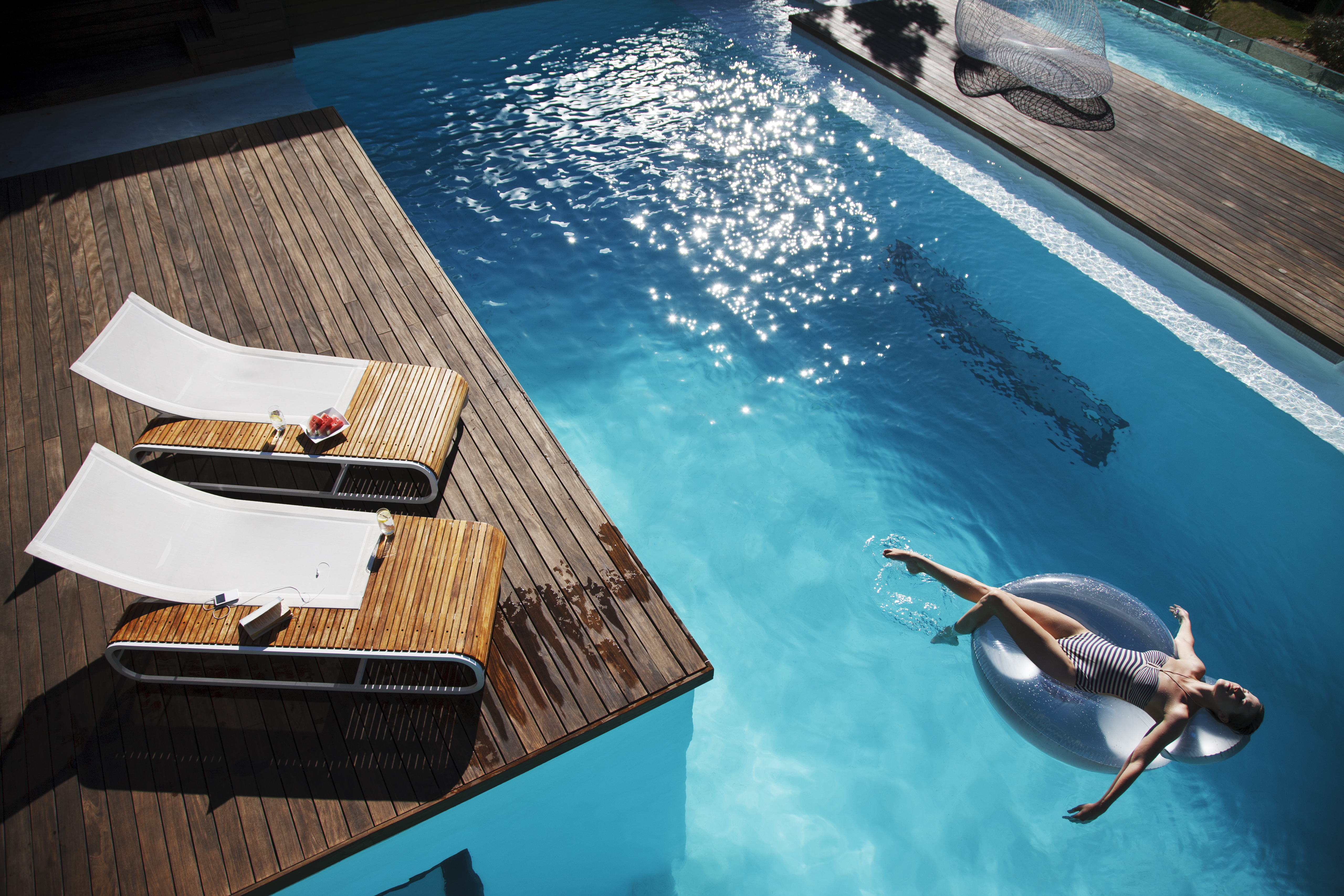 Woman floating on inflatable ring in luxury swimming pool