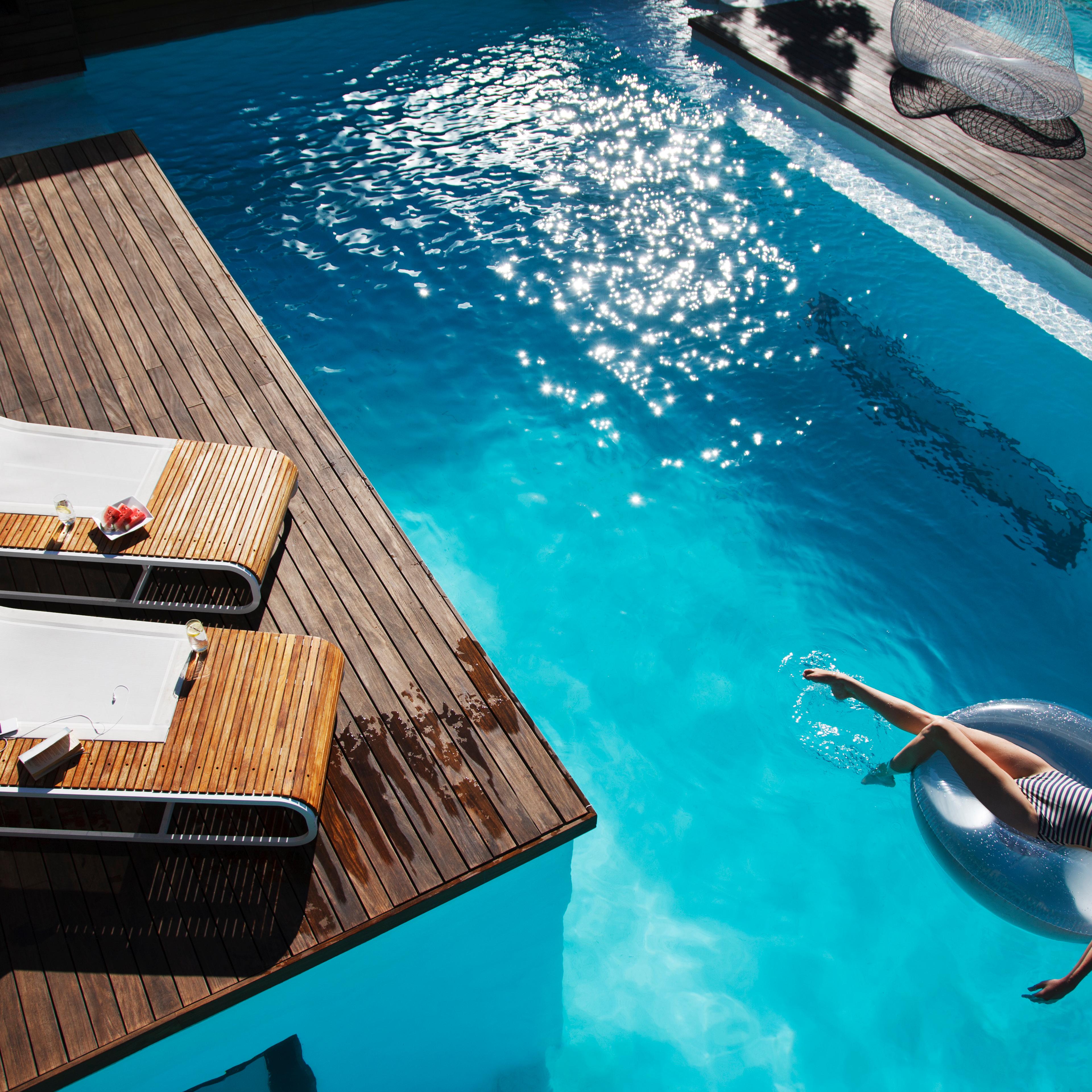 Woman floating on inflatable ring in luxury swimming pool