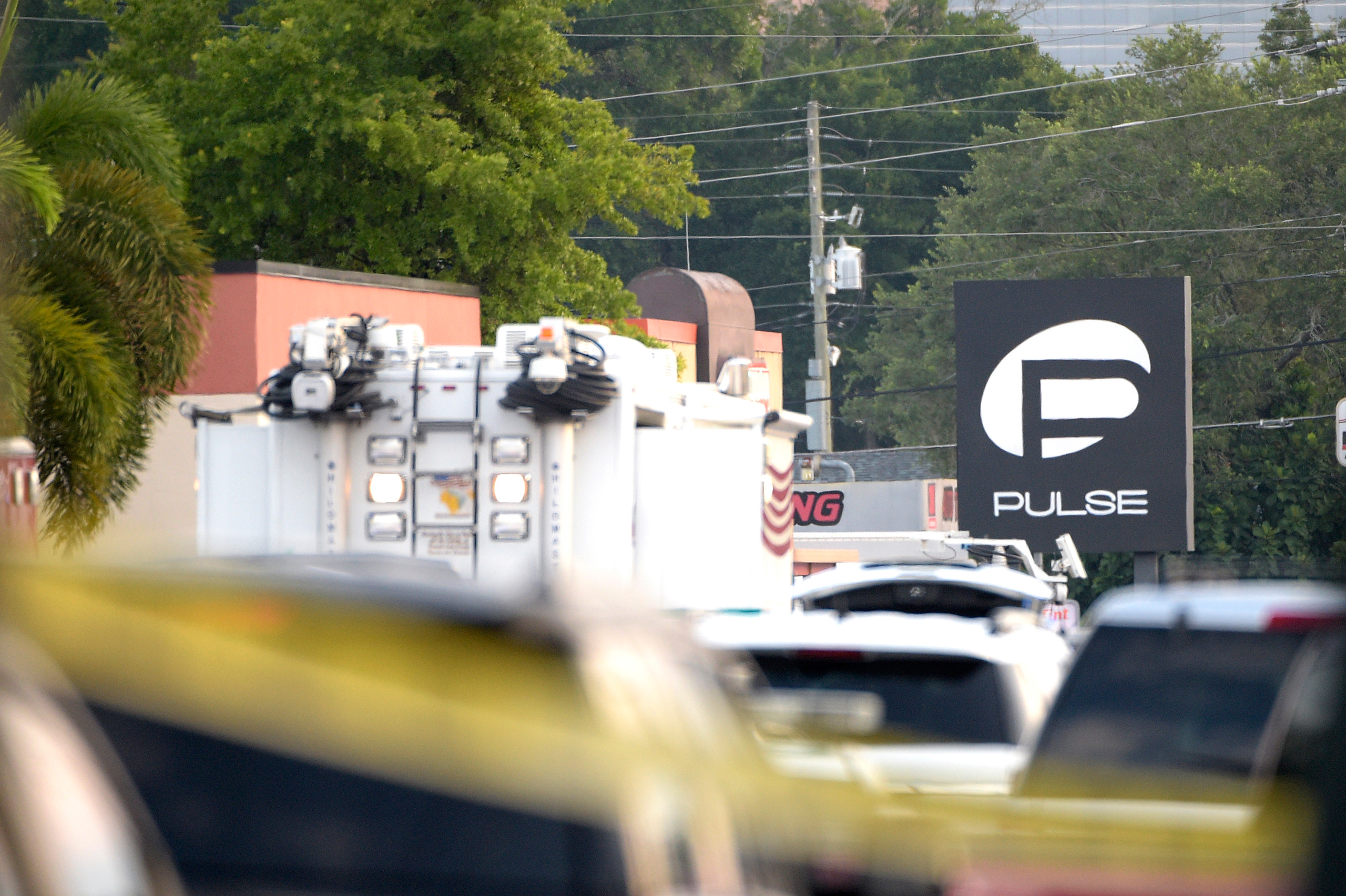 Police cars and emergency vehicles surround the Pulse Orlando nightclub, the scene of a fatal shooting, in Orlando, Fla., Sunday, June 12, 2016. (AP Photo/Phelan M. Ebenhack)