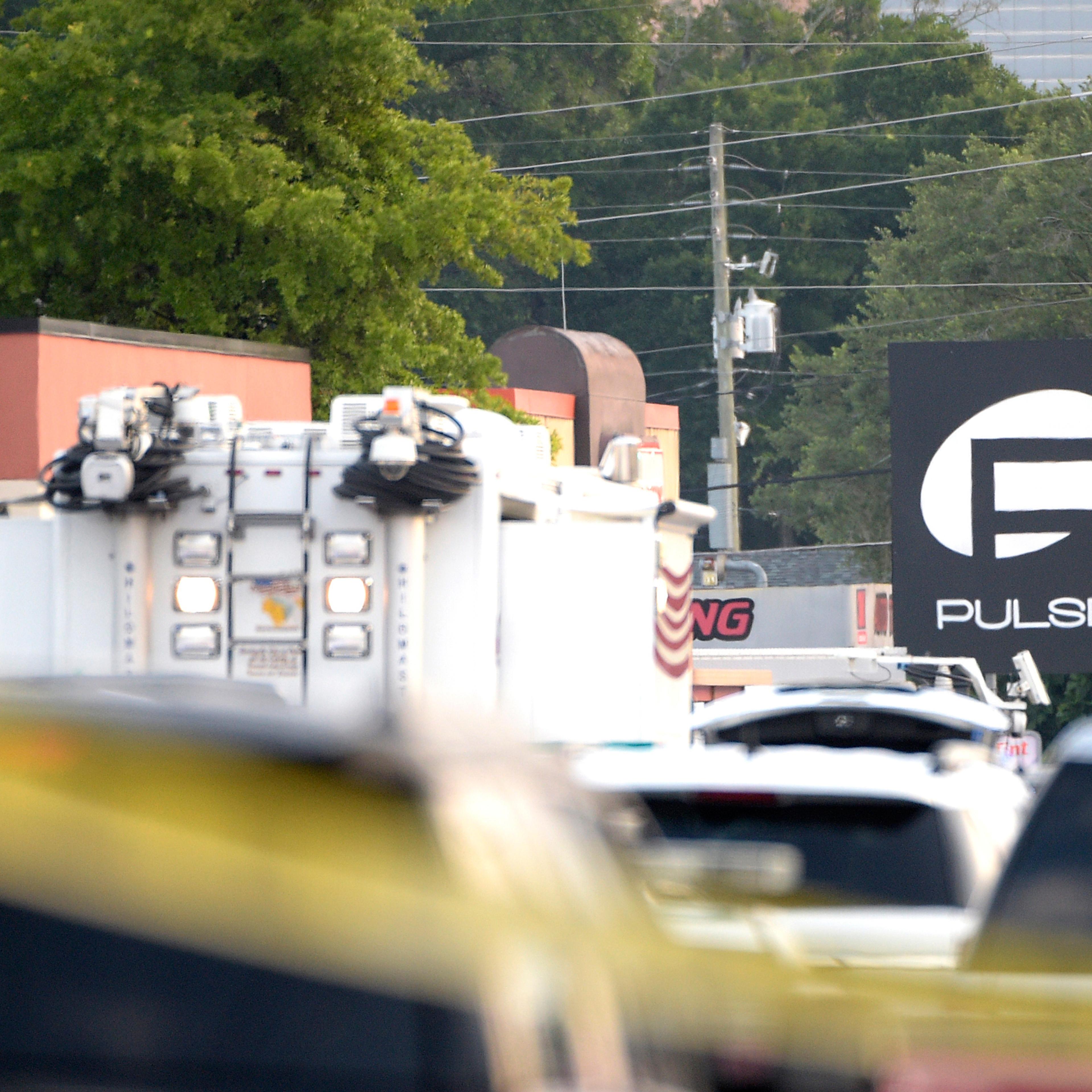 Police cars and emergency vehicles surround the Pulse Orlando nightclub, the scene of a fatal shooting, in Orlando, Fla., Sunday, June 12, 2016. (AP Photo/Phelan M. Ebenhack)