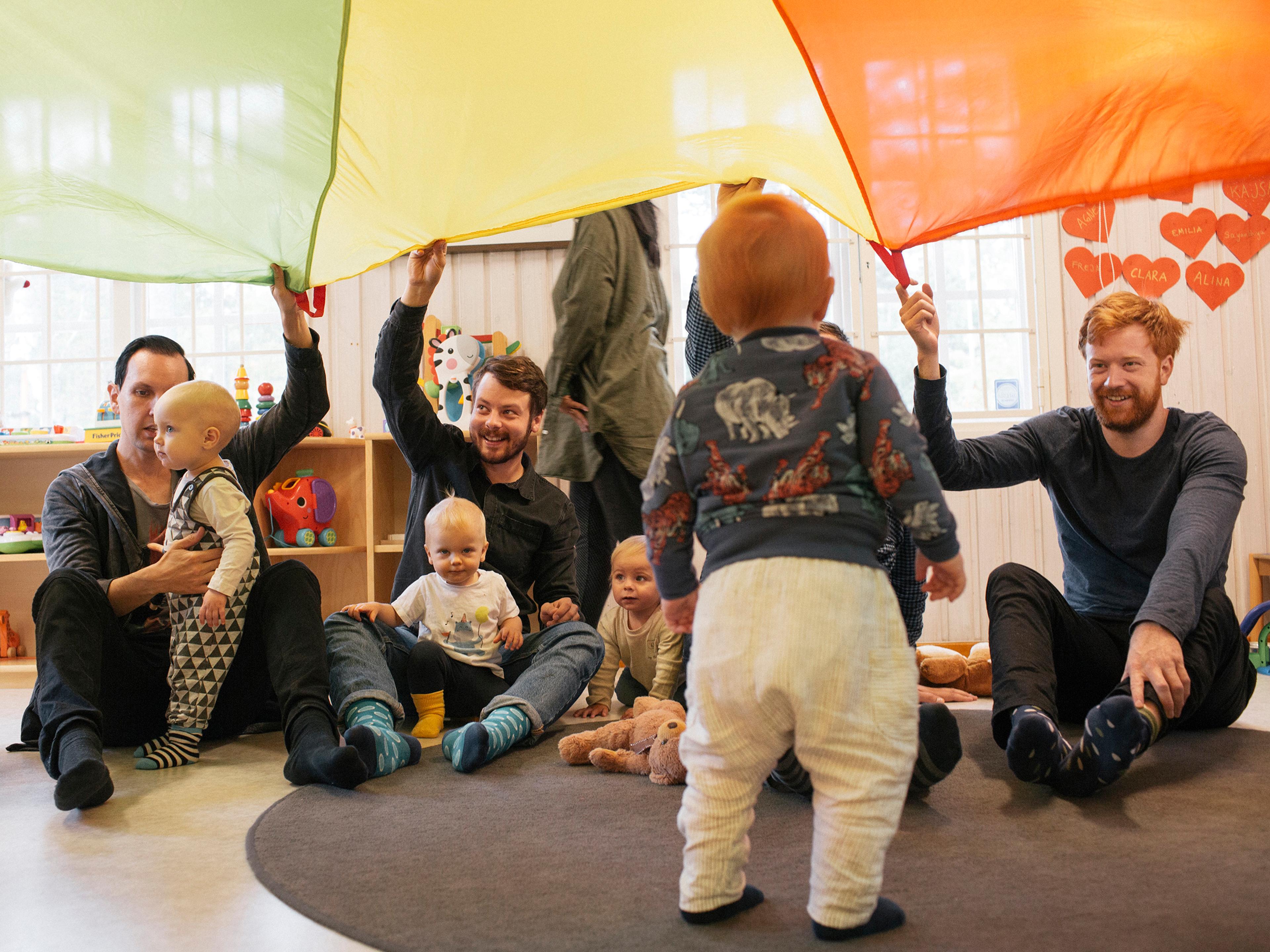 fathers and children in Stockholm play at a center where parents on leave gather to socialize