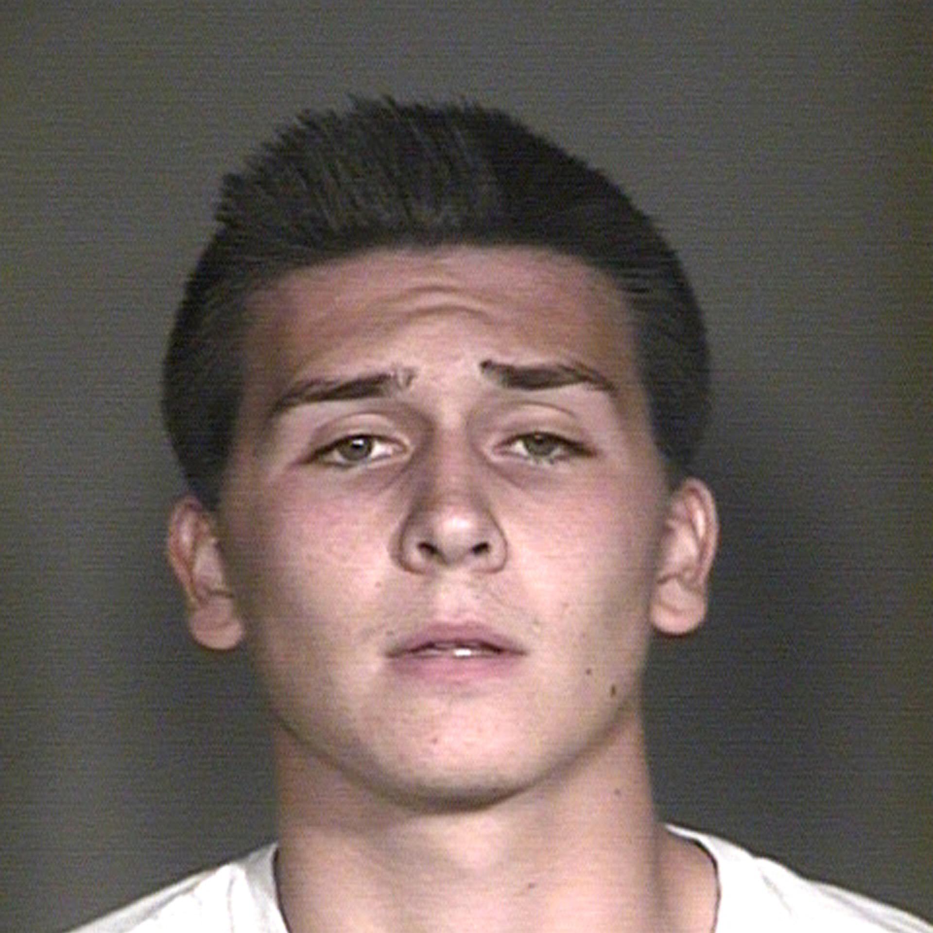 This undated booking photo provided by the Mesa Police Department, in Mesa, Ariz., shows Hunter Osborn. The Arizona high school student is facing dozens of charges after police say he exposed himself in a football team picture that ended up in a yearbook