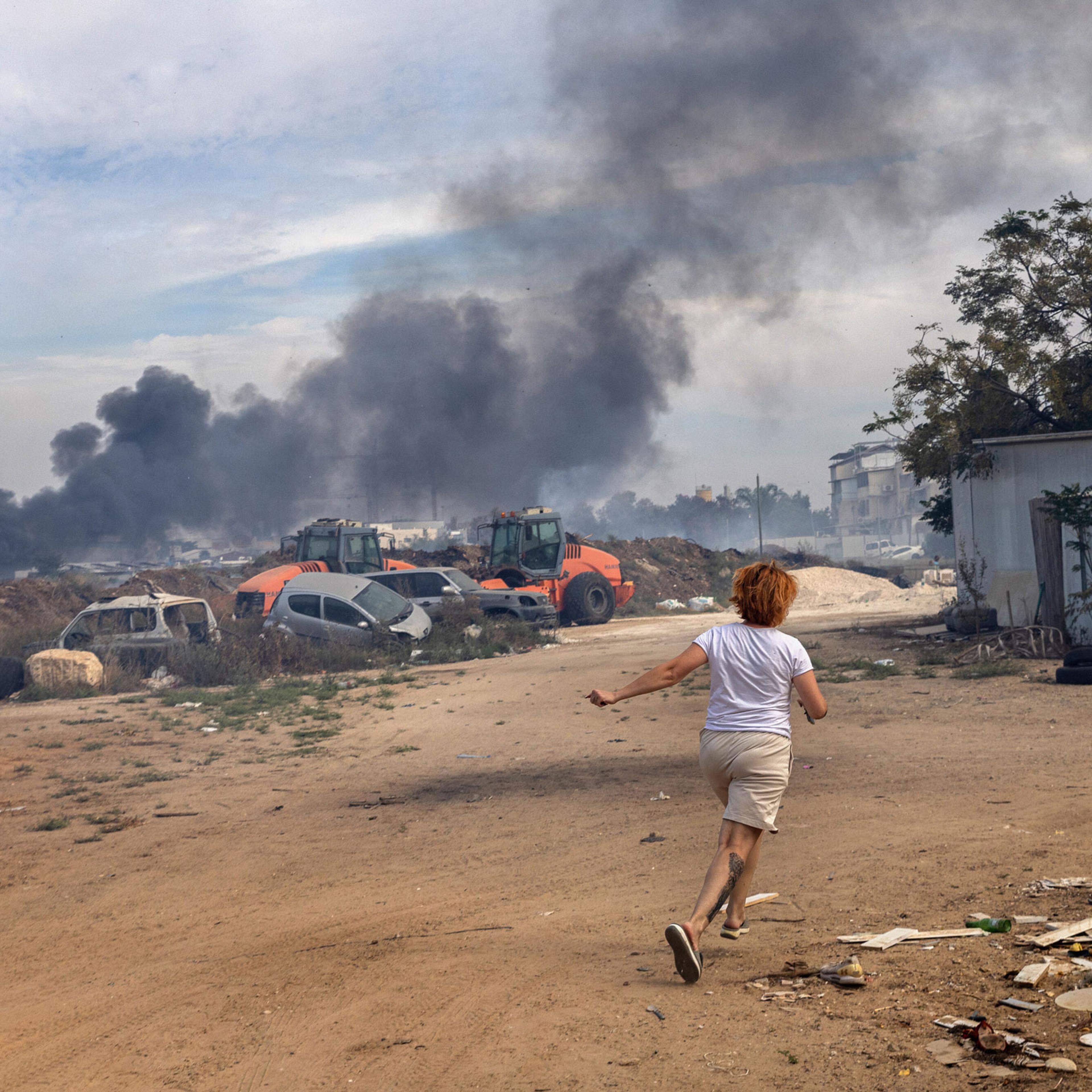 An Israeli runs to a shelter in Ashkelon on Oct. 7