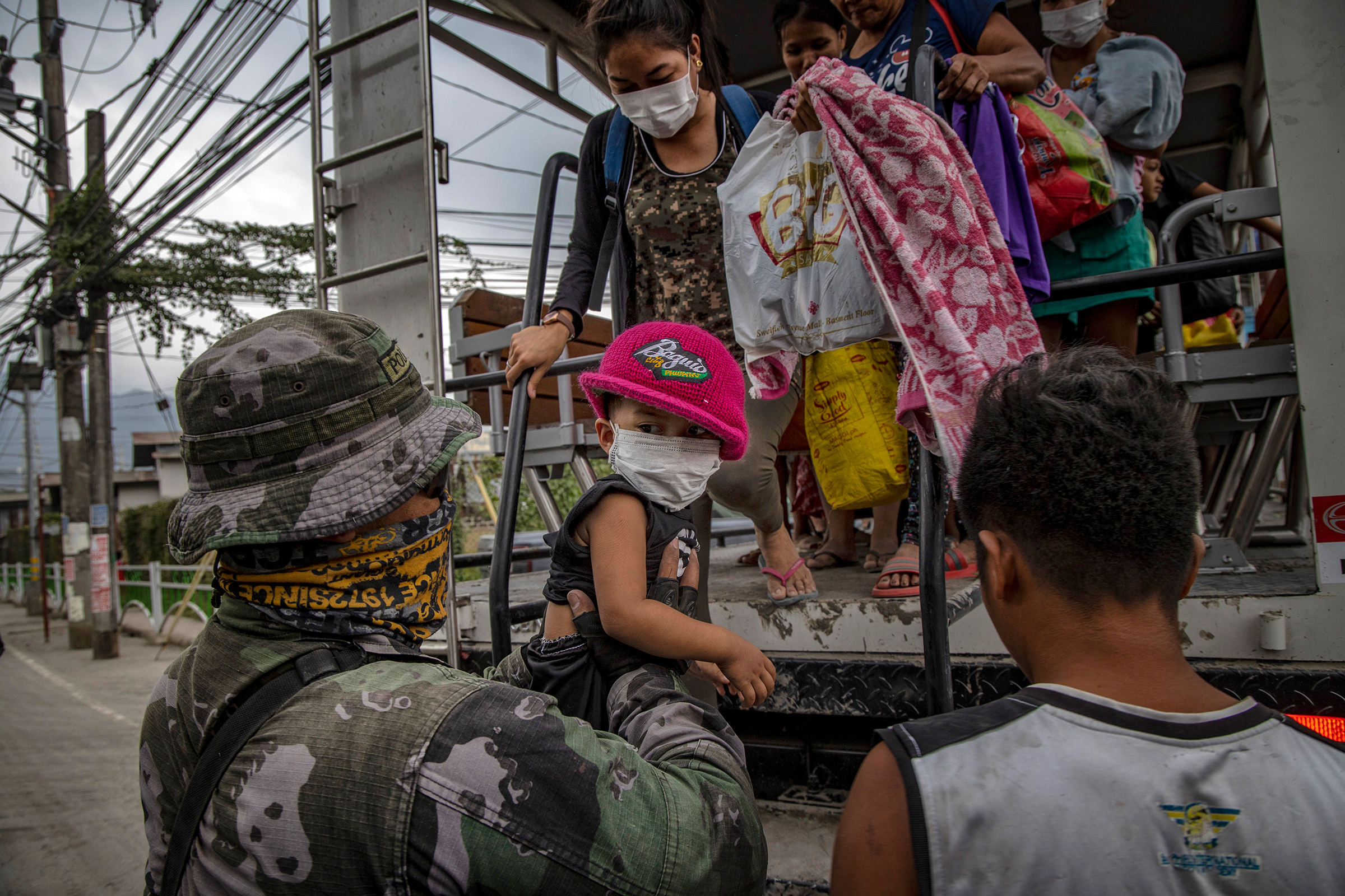 Residents fleeing the eruption arrive to an evacuation center in Santo Thomas on Jan. 13.