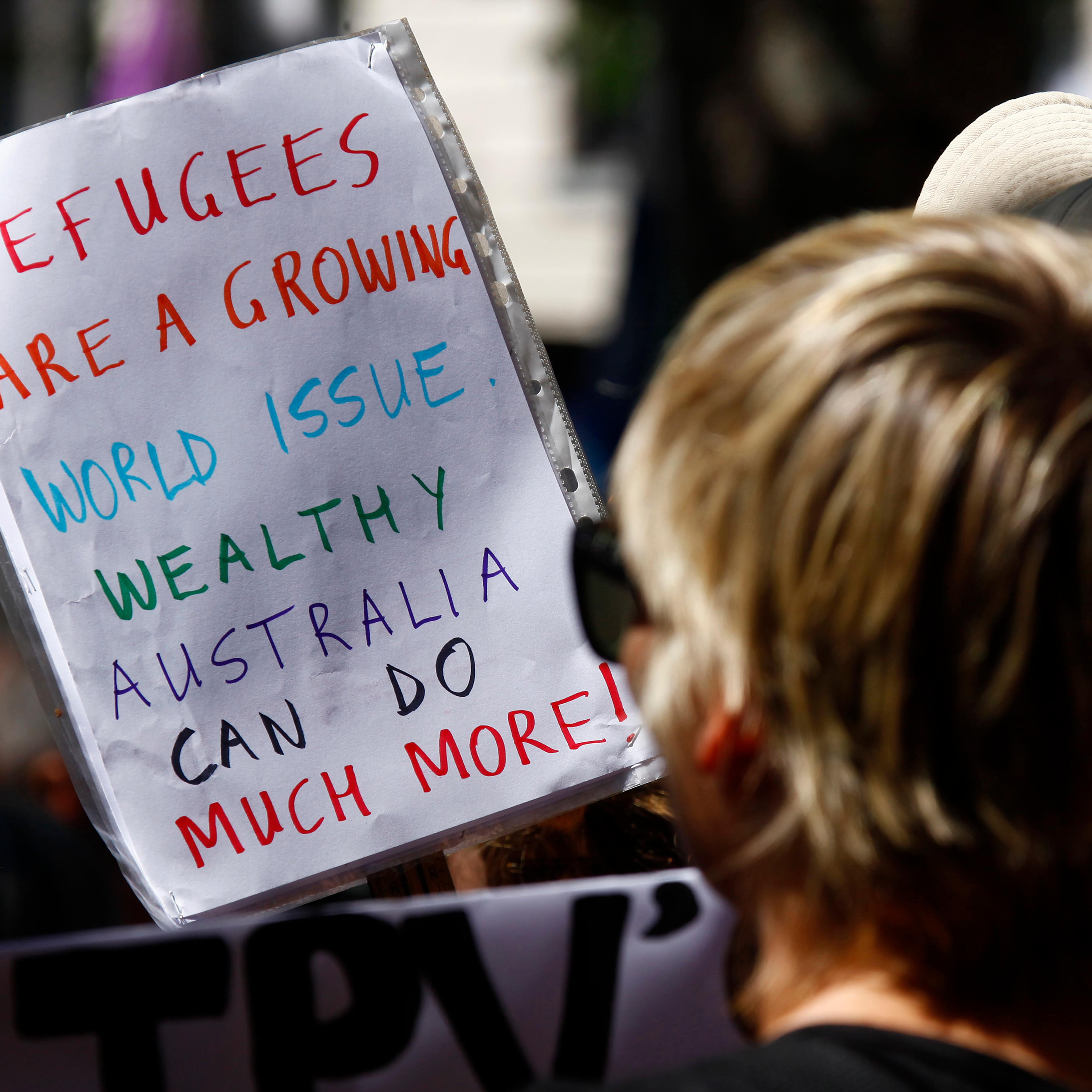 Protesters hold placards at the 'Stand up for Refugees' rally held in central Sydney