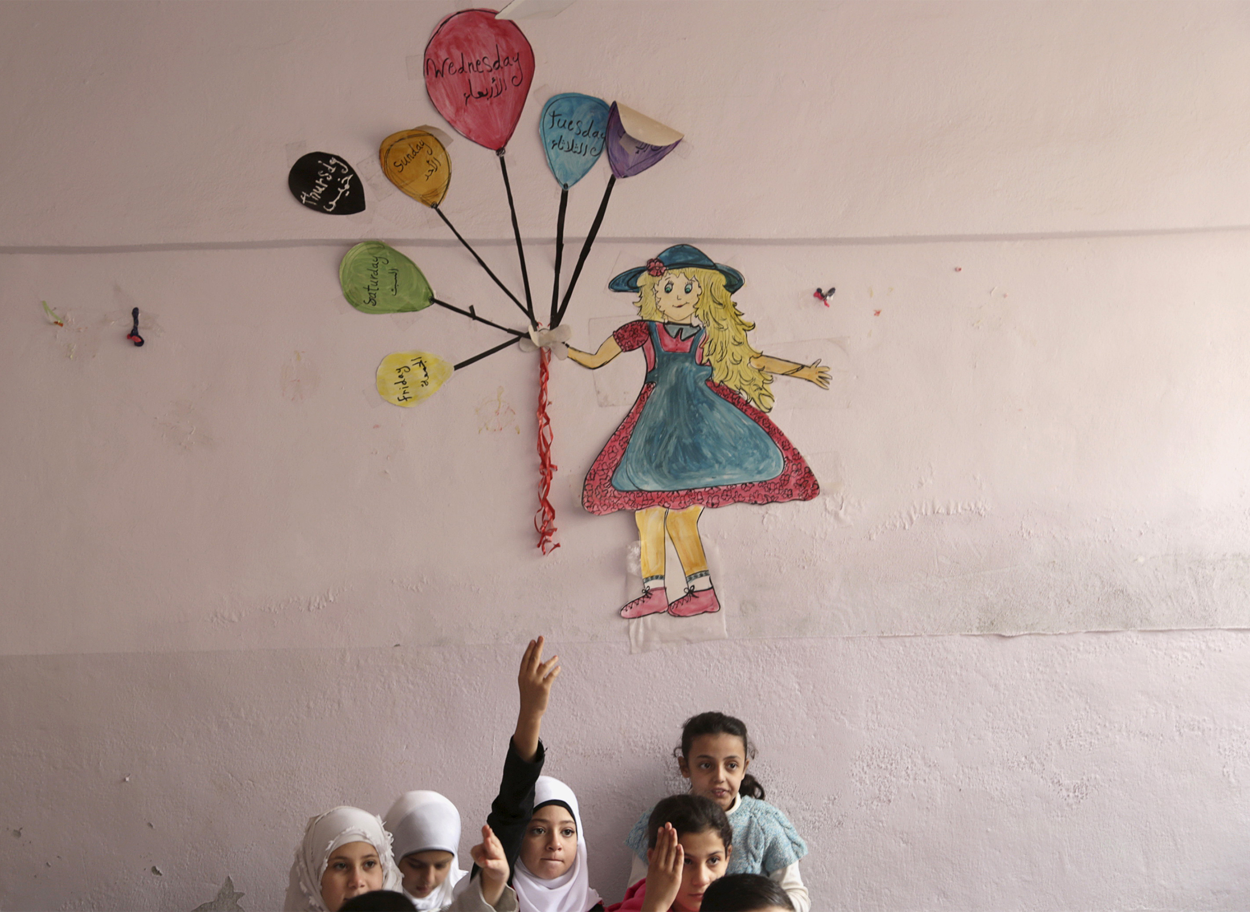 Students attend a class inside Hosam Kamel school in the rebel-controlled area of Maaret al-Numan town in Idlib province, Syria on October 28, 2015. The school, which was bombed and partially destroyed, started the new school year after restoration work was completed, activists said.