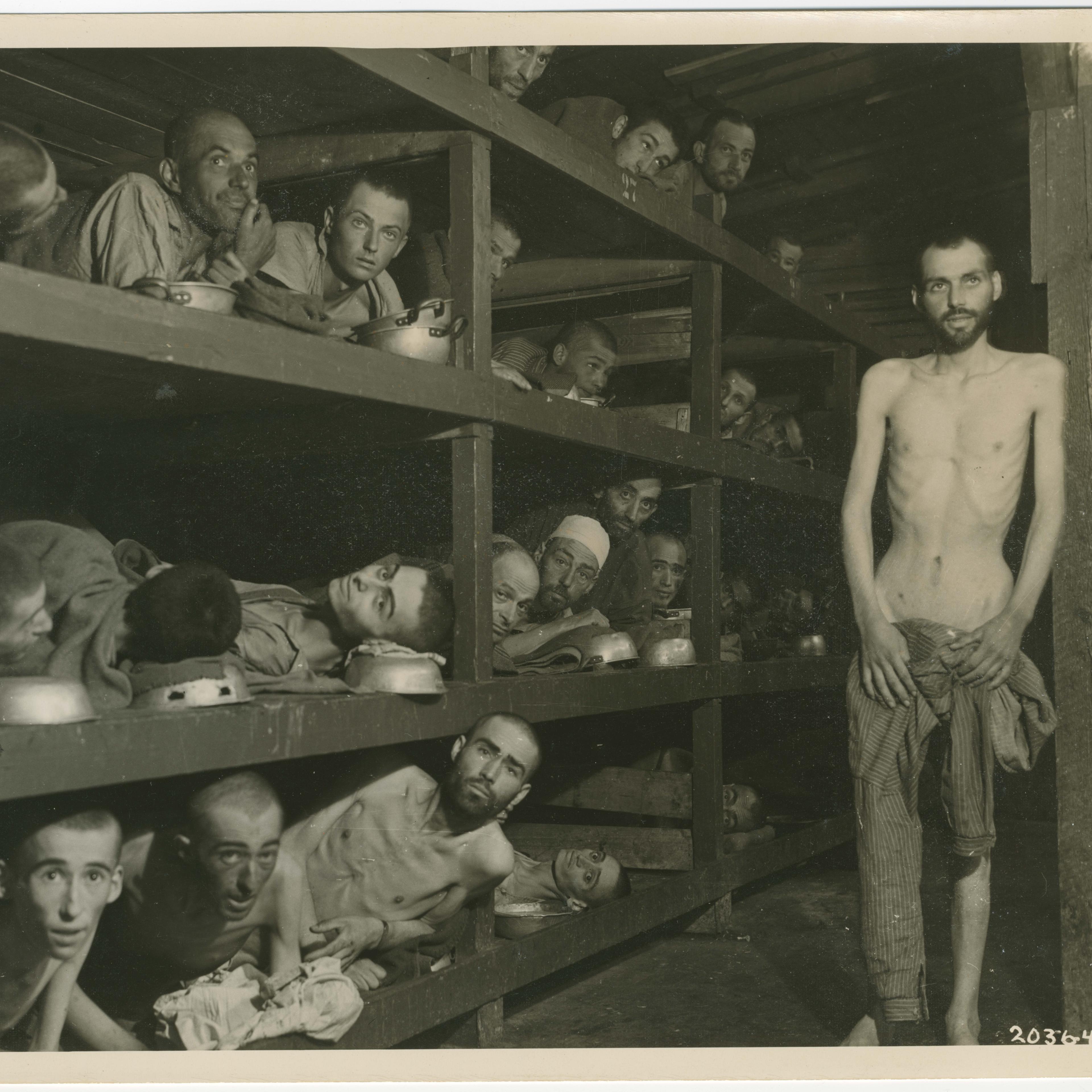 Former prisoners in the Buchenwald concentration camp, pictured in the wooden bunks where they slept on April 16, 1945. Elie Wiesel is pictured in the second row of bunks, seventh from the left, next to the vertical beam.