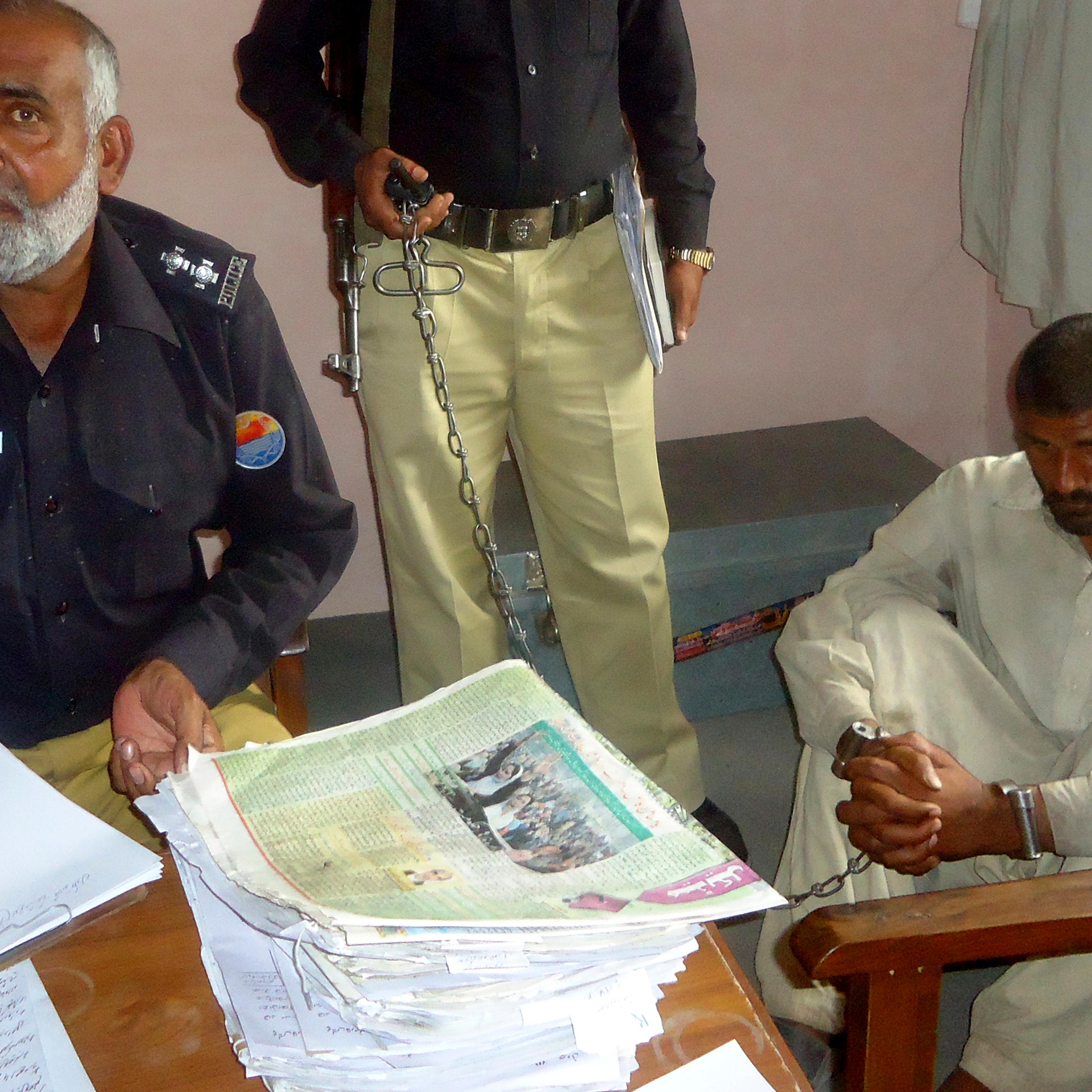 Mohammad Arif sits in a police custody at a police station, in the town of Darya Khan