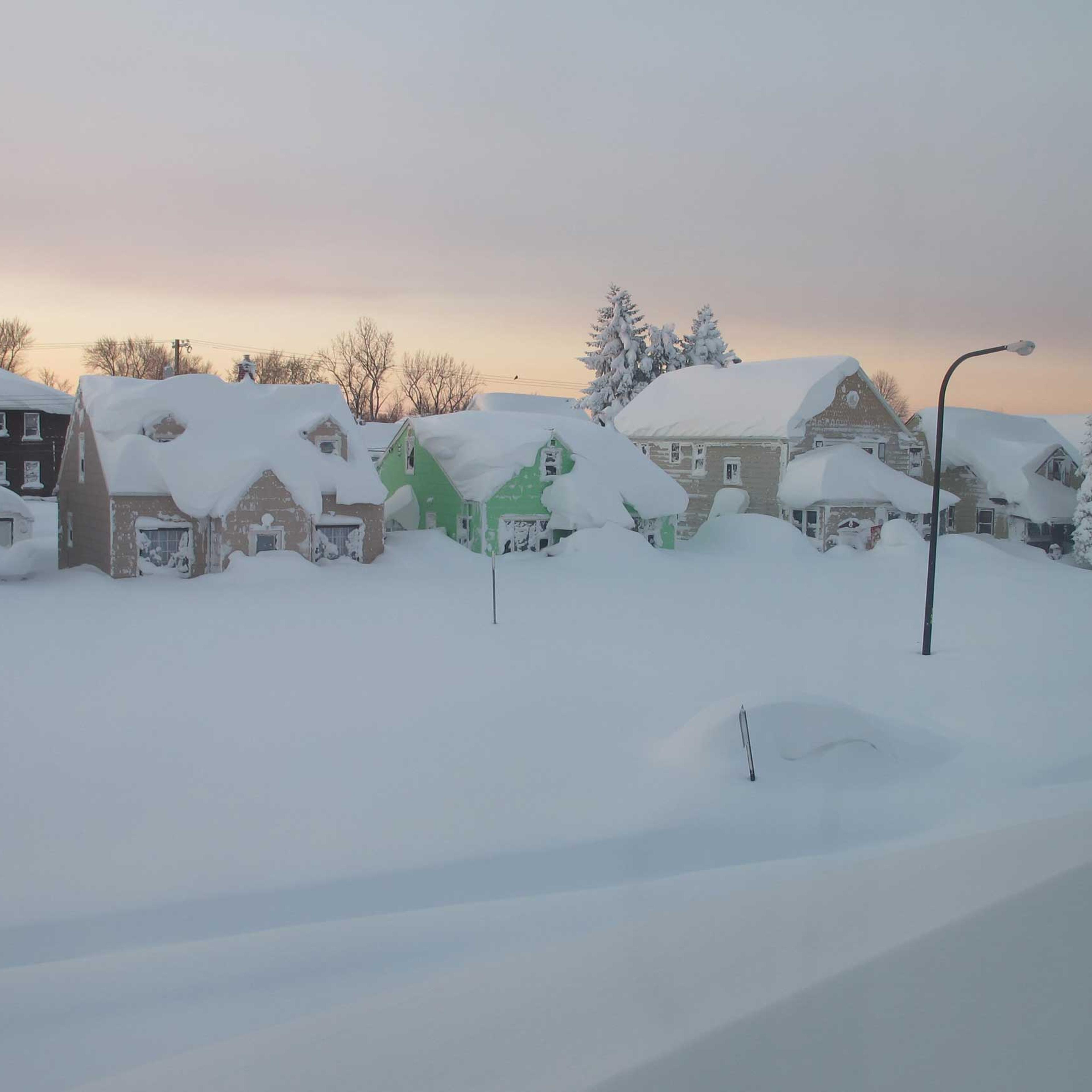 Snow covers a street at daybreak Wednesday, Nov. 19, 2014, in south Buffalo, N.Y.