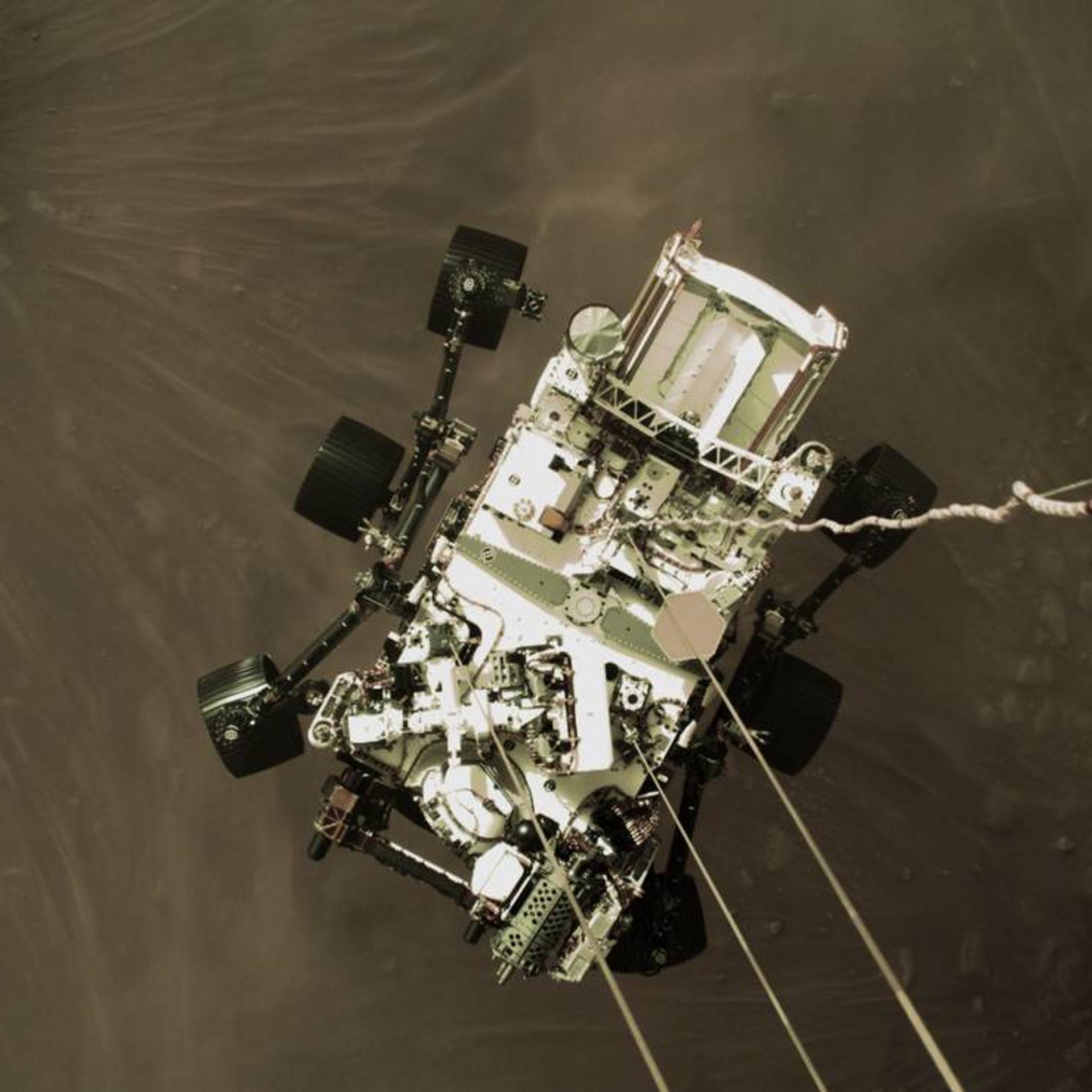 The Perseverance rover is lowered to the surface of Mars on Feb. 18 in image captured by the spacecraft's descent stage.