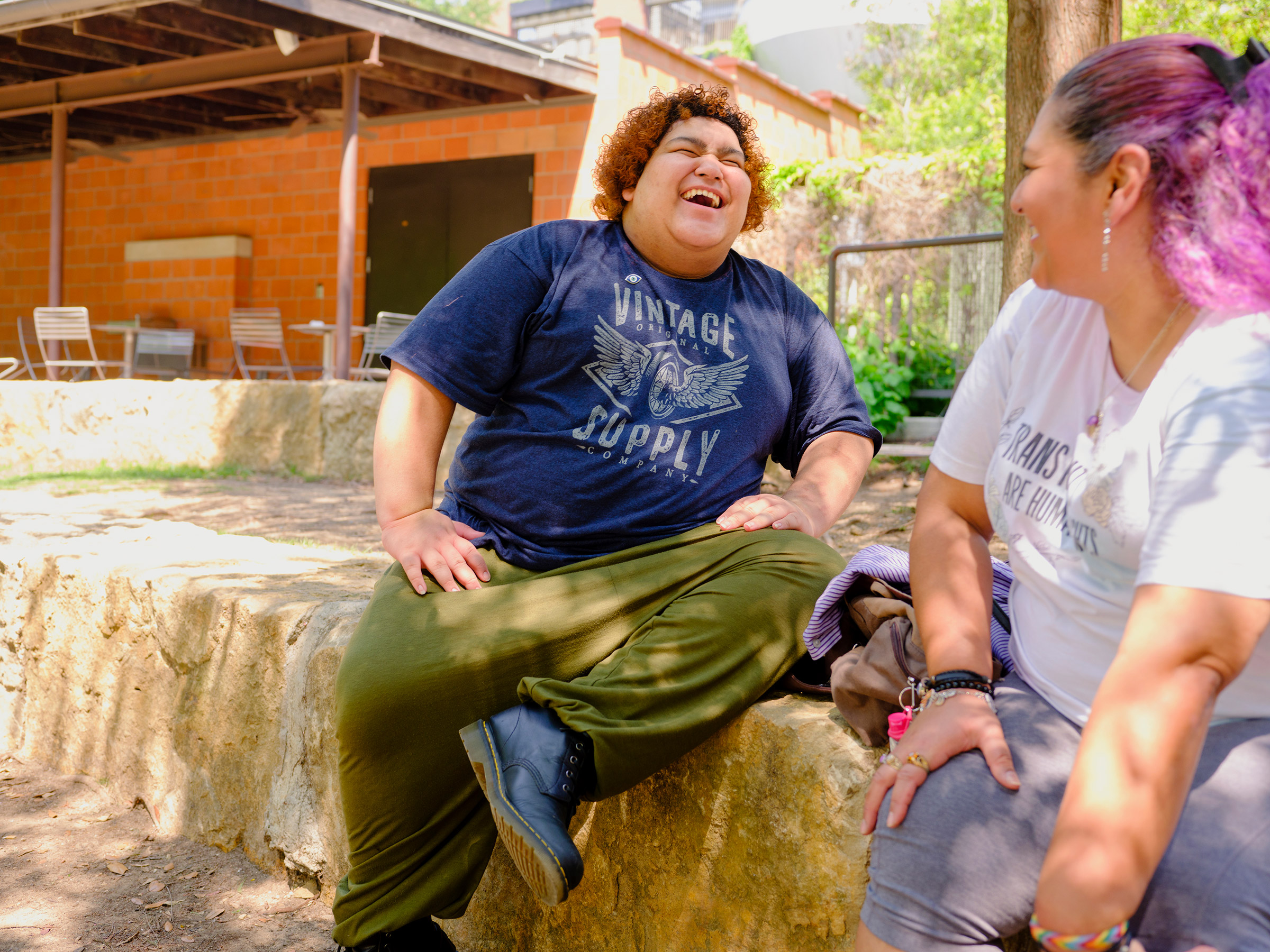 Vienna, 16, sits with their mom in San Antonio. Vienna will start college in the fall and hopes to study journalism. They say they are fascinated by the way “journalism affects how we as a society get our information.” In their future reporting, Vienna h