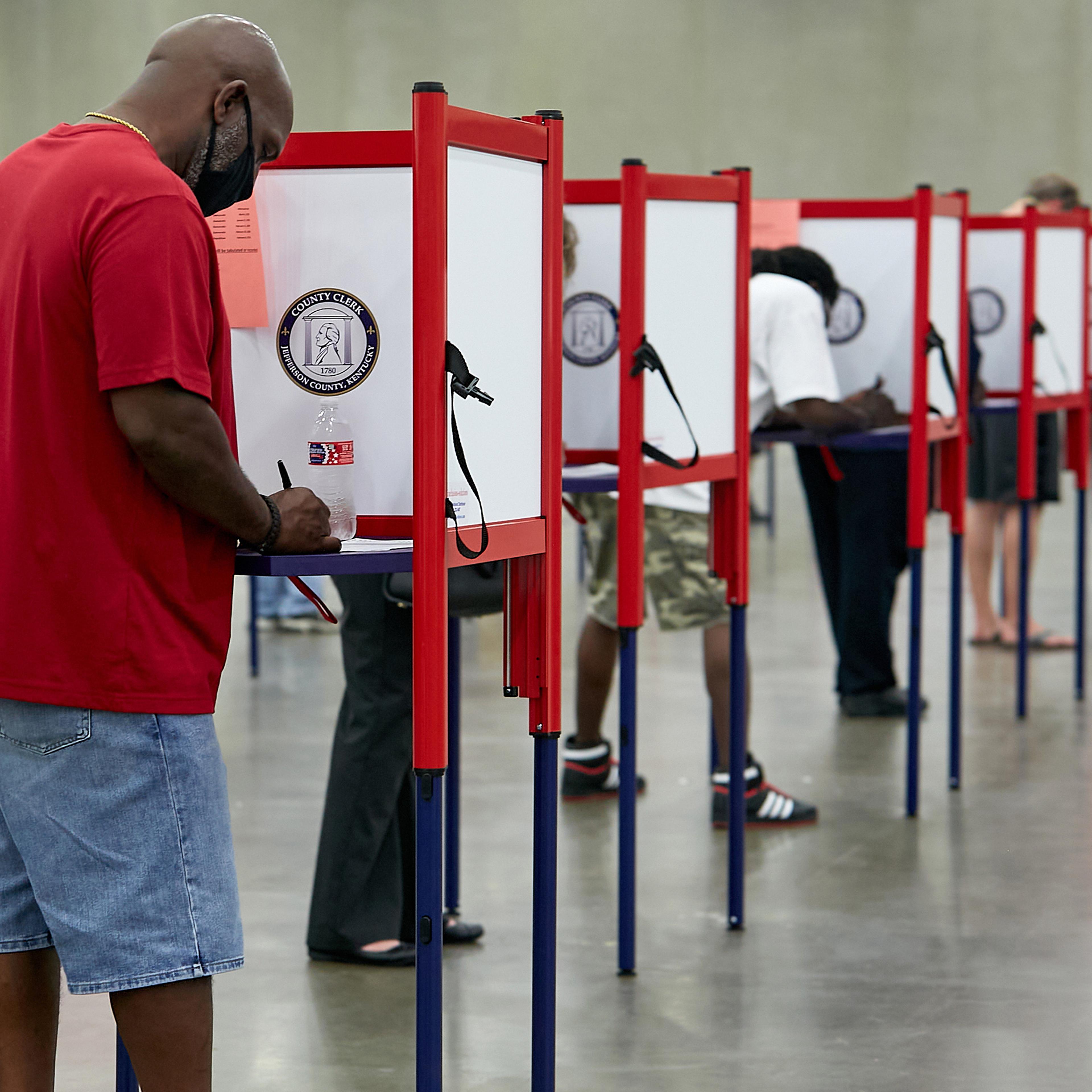 Primary voters cast their ballots at a polling place in Louisville, Ky., on June 23