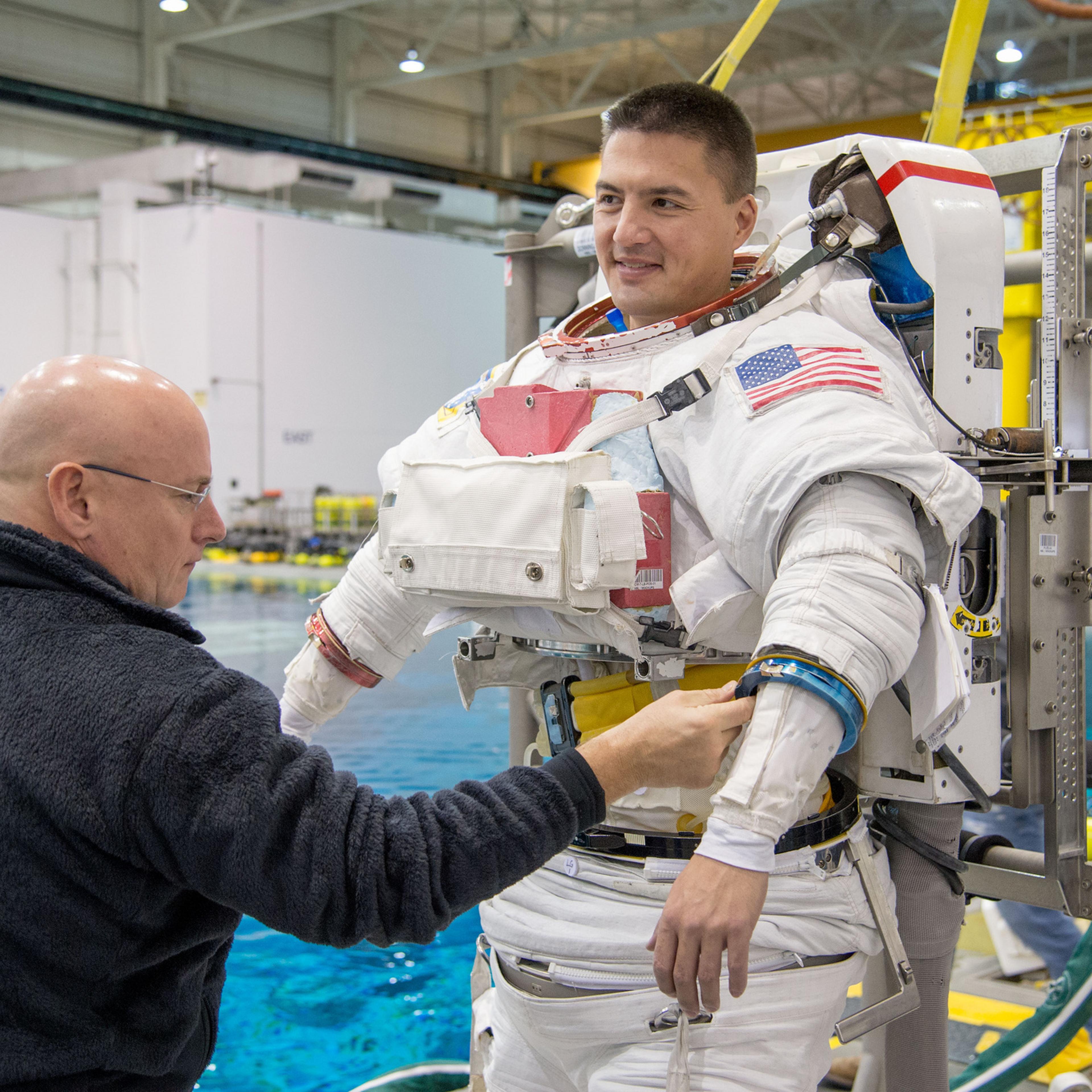 Preparing to make a house call: Scott Kelly, currently aboard the space station for a one-year stay, checks out spacewalk suit of space doc Kjell Lindgren, who blasts off next month