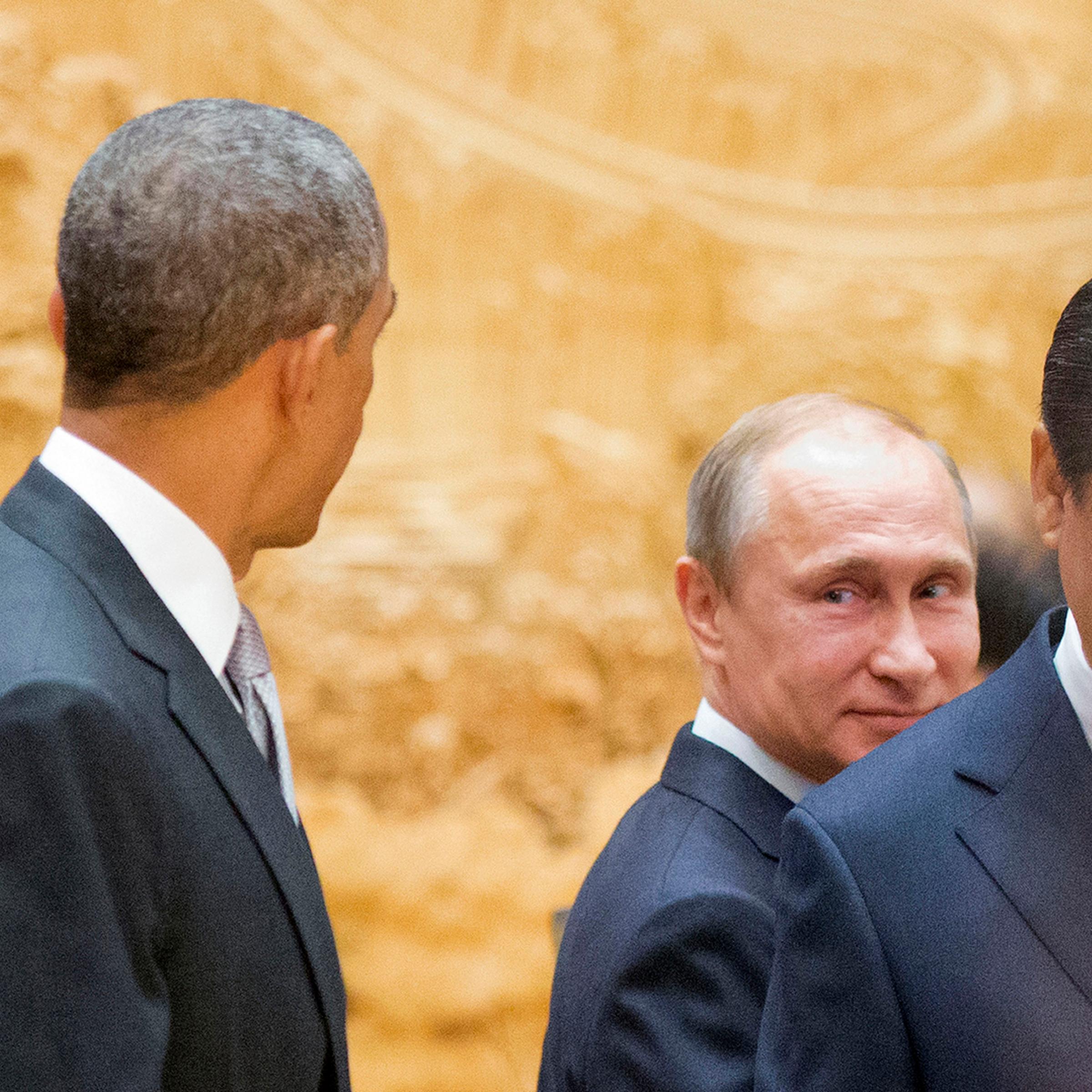 Putin looks back at Obama as they arrive with Xi Jinping at APEC Summit plenary session in Beijing