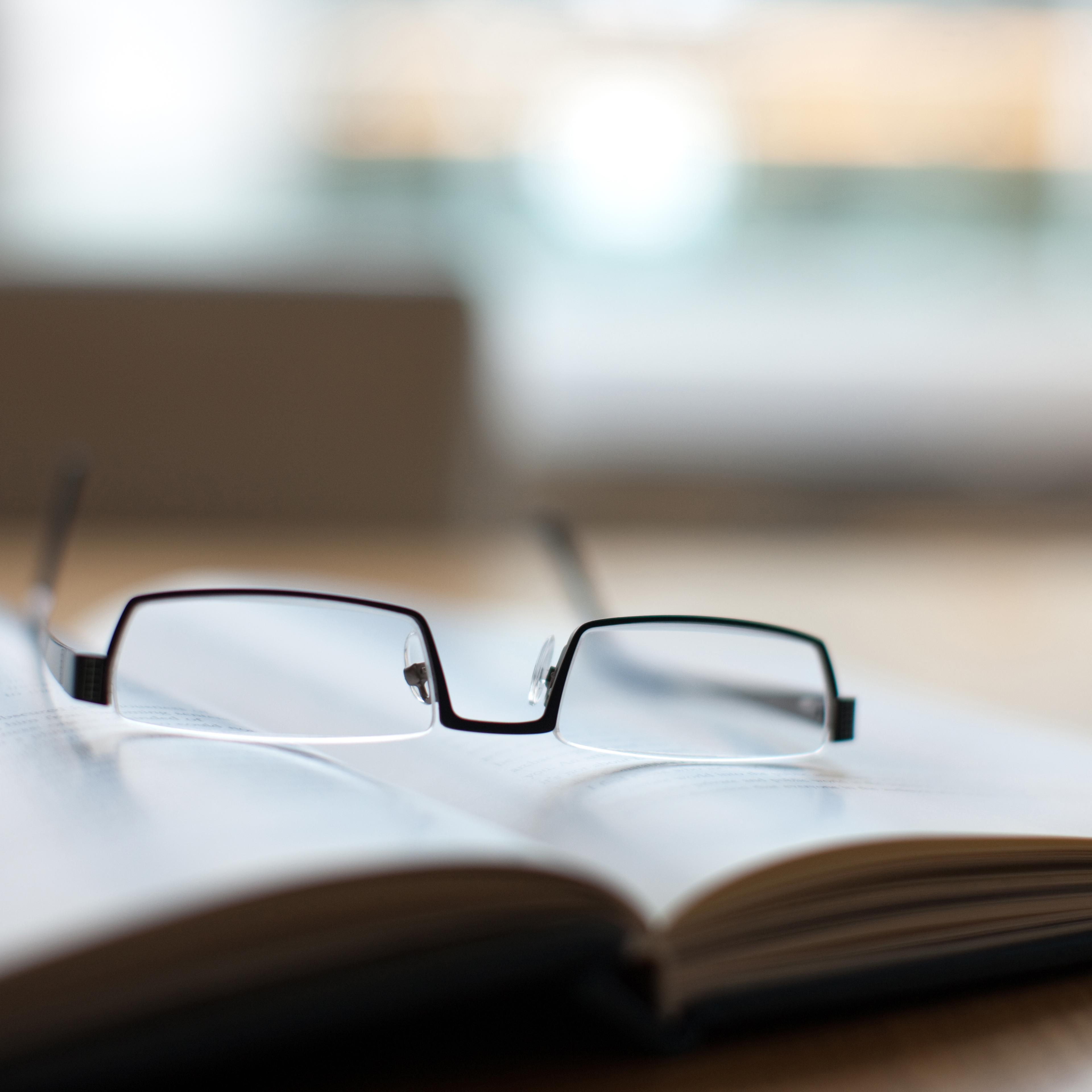 Eyeglasses and book on conference table