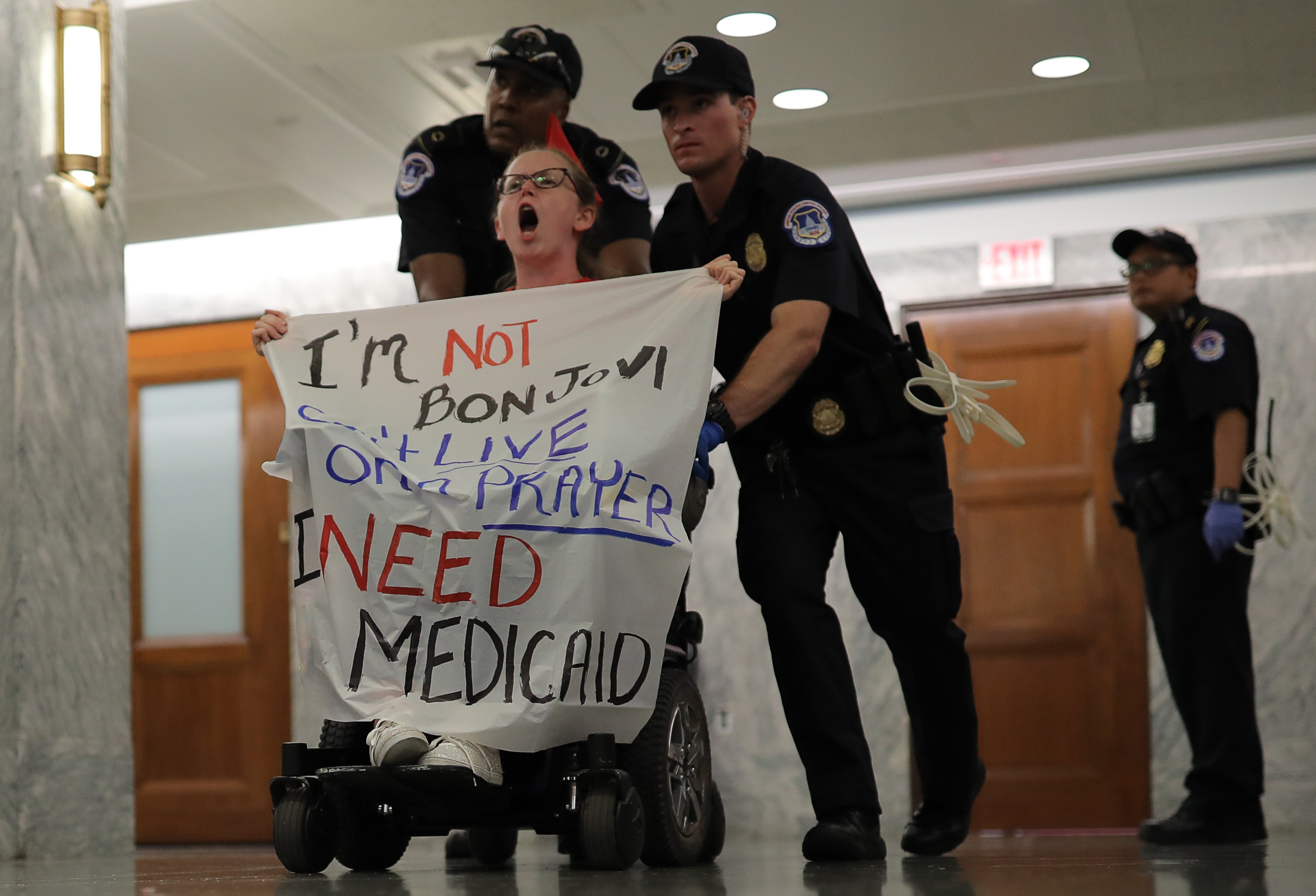 A protester is led away by Capitol Hill police officers outside a Senate Finance Committee hearing on the latest Republican effort to repeal and replace the Affordable Care Act on Capitol Hill in Washington, D.C. Sept. 25, 2017.