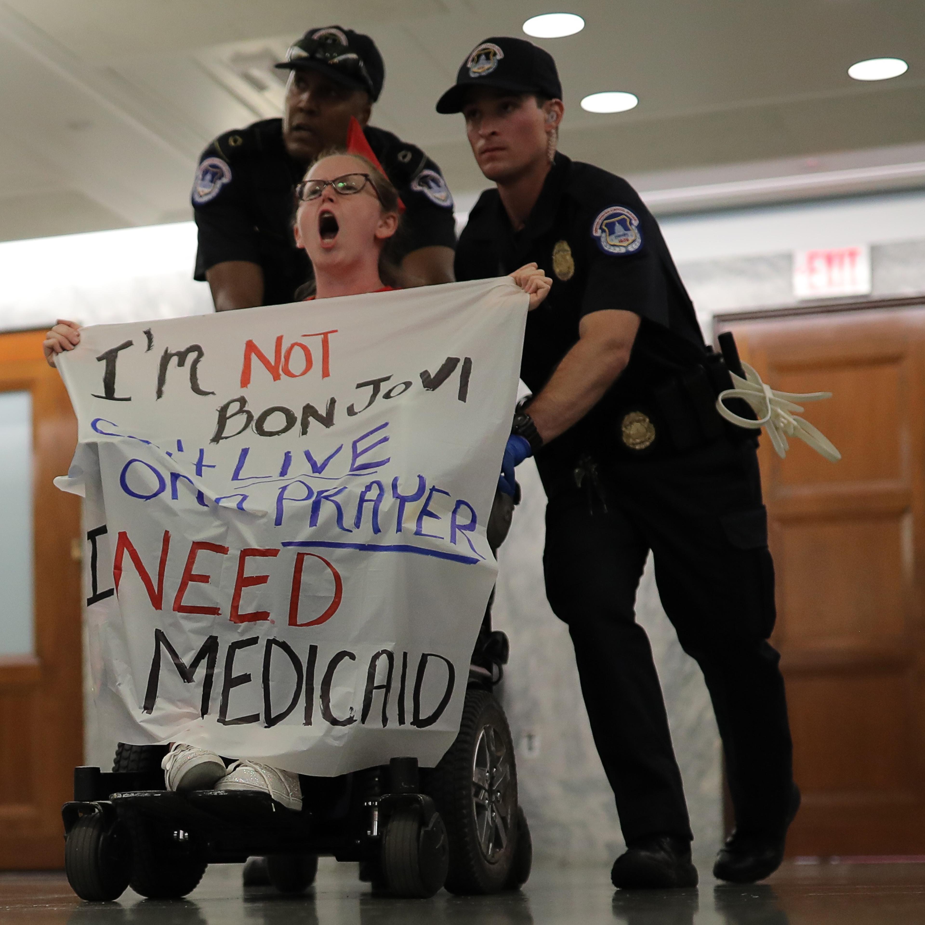 A protester is led away by Capitol Hill police officers outside a Senate Finance Committee hearing on the latest Republican effort to repeal and replace the Affordable Care Act on Capitol Hill in Washington, D.C. Sept. 25, 2017.