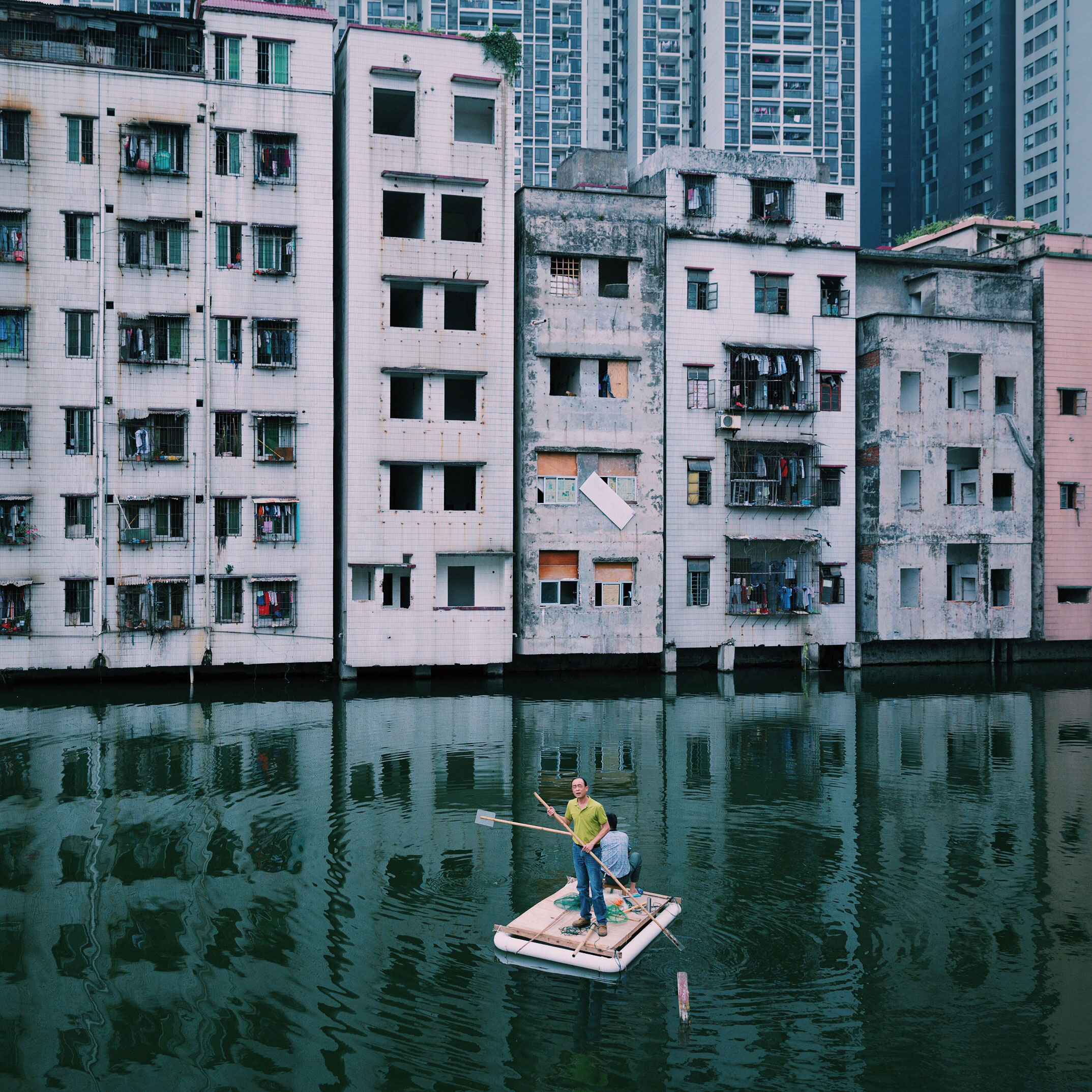 Two men fish in a pond in Xian Village, which is in the city center of Guangzhou, China. A conflict between locals and real estate developers lasts for more than seven years because of the uneven compensation and the corruption of Xian village leaders. 