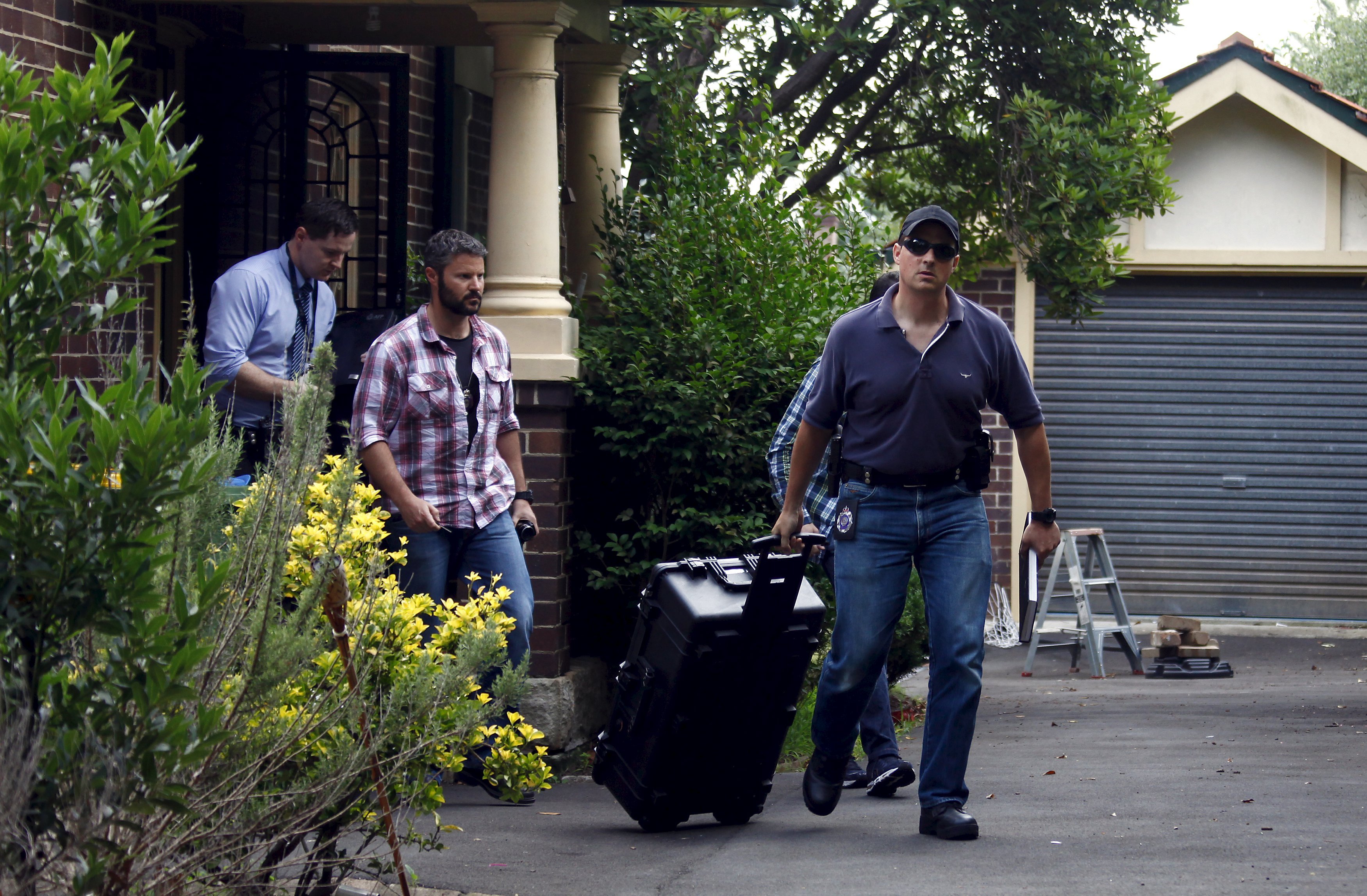 Australian Federal Police officers walk down the driveway after searching the home of probable creator of cryptocurrency bitcoin Craig Steven Wright in Sydney's north shore December 9, 2015.