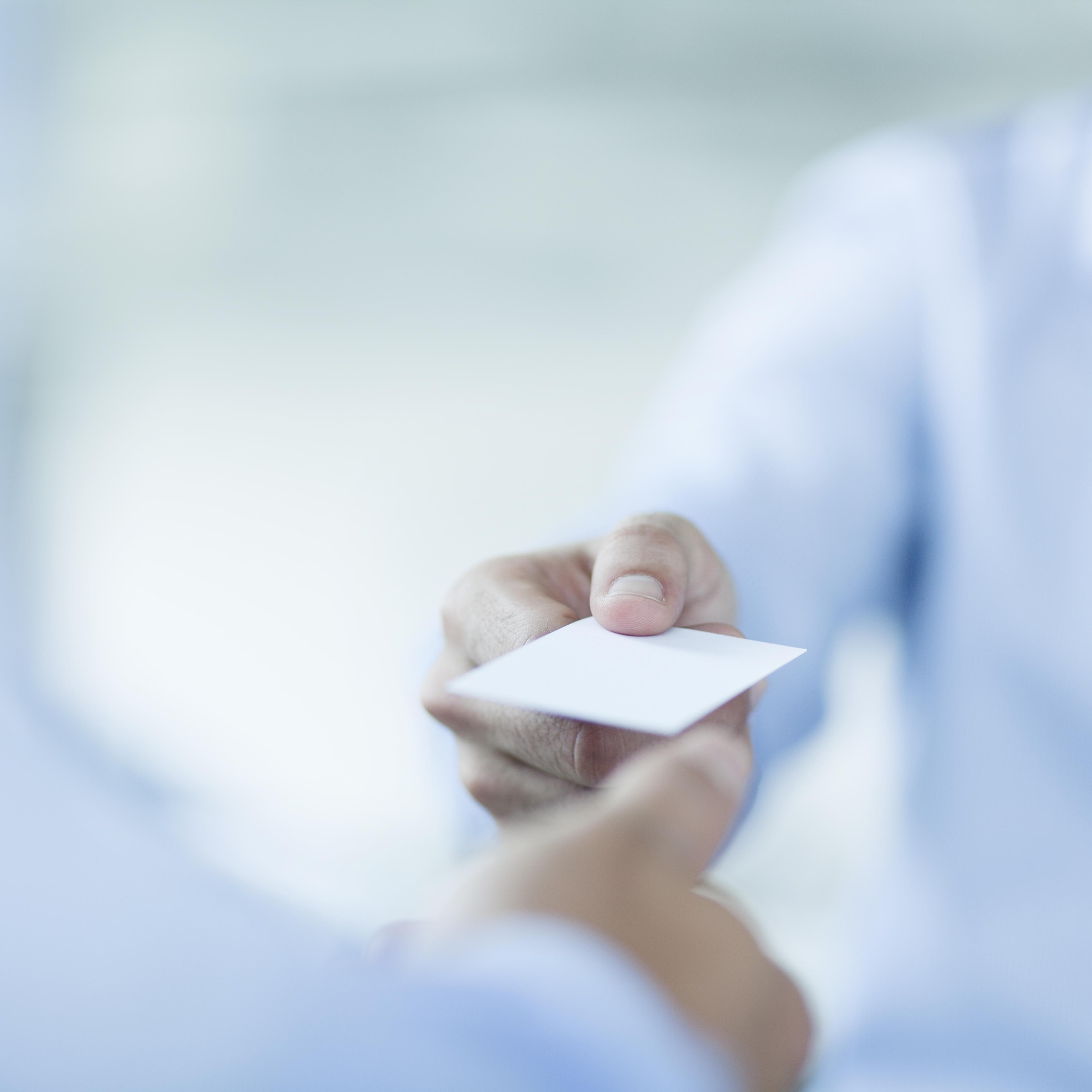 Close up of two businessmen exchanging business cards