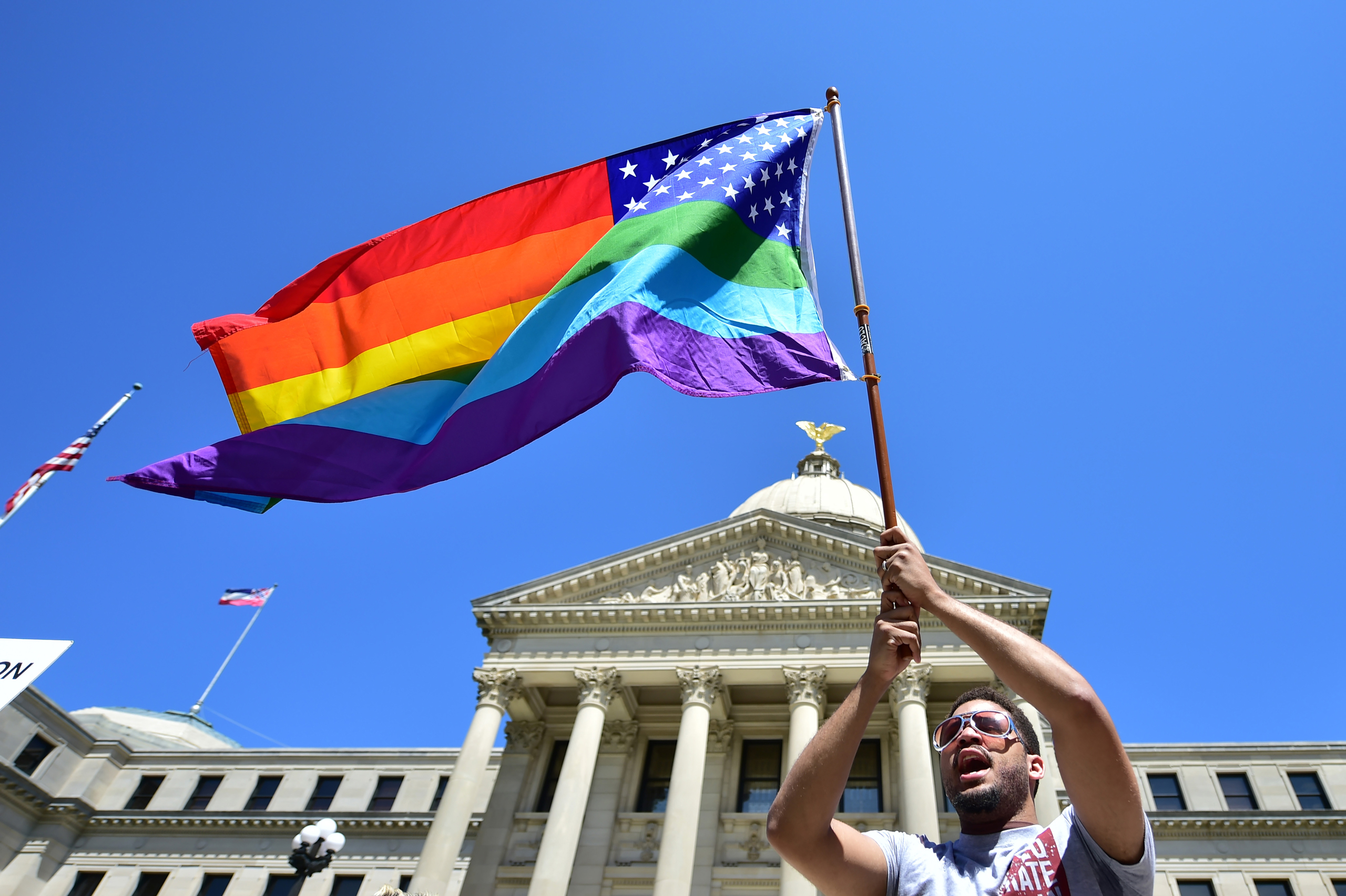 Meridian resident Nykolas Alford waves a rainbow-colored flag designed with the U.S. flag during a Human Rights Campaign protest of House Bill 1523 on the Mississippi State Capitol steps in Jackson, Miss., Tuesday, March 29, 2016. (Justin Sellers/The Cla
