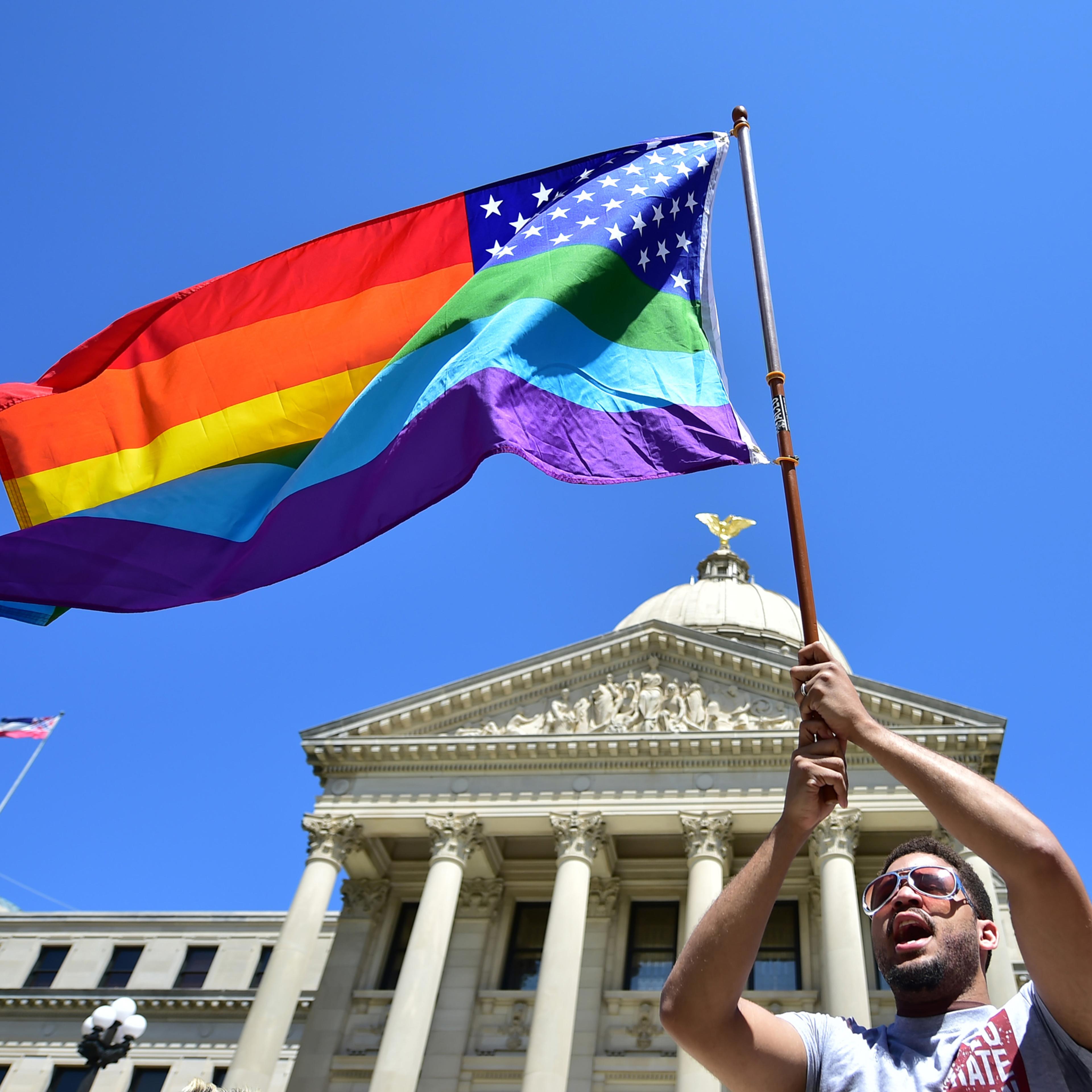 Meridian resident Nykolas Alford waves a rainbow-colored flag designed with the U.S. flag during a Human Rights Campaign protest of House Bill 1523 on the Mississippi State Capitol steps in Jackson, Miss., Tuesday, March 29, 2016. (Justin Sellers/The Cla