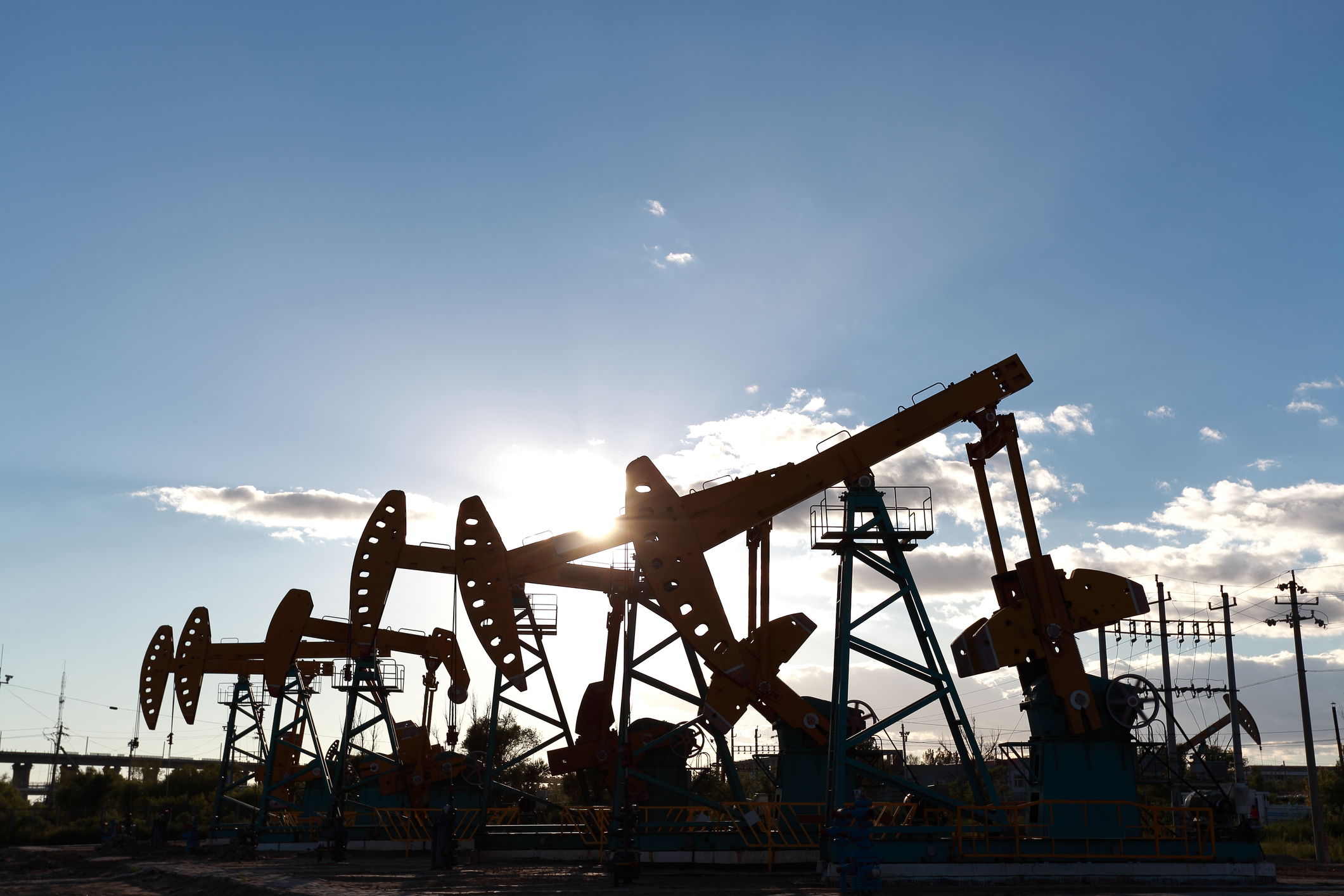 Golden yellow oil rig energy industry machine oil crude In the sunset backlighting
