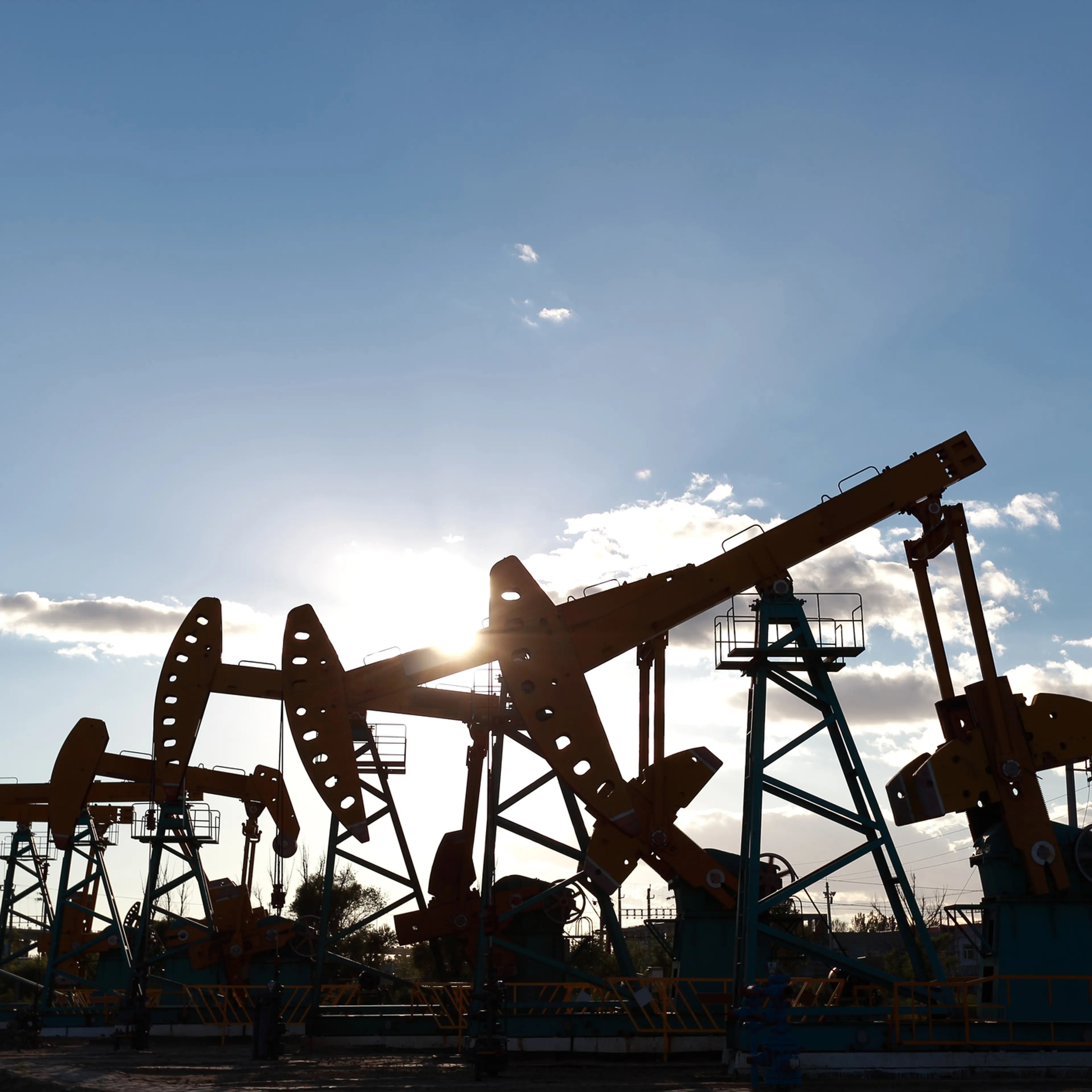 Golden yellow oil rig energy industry machine oil crude In the sunset backlighting