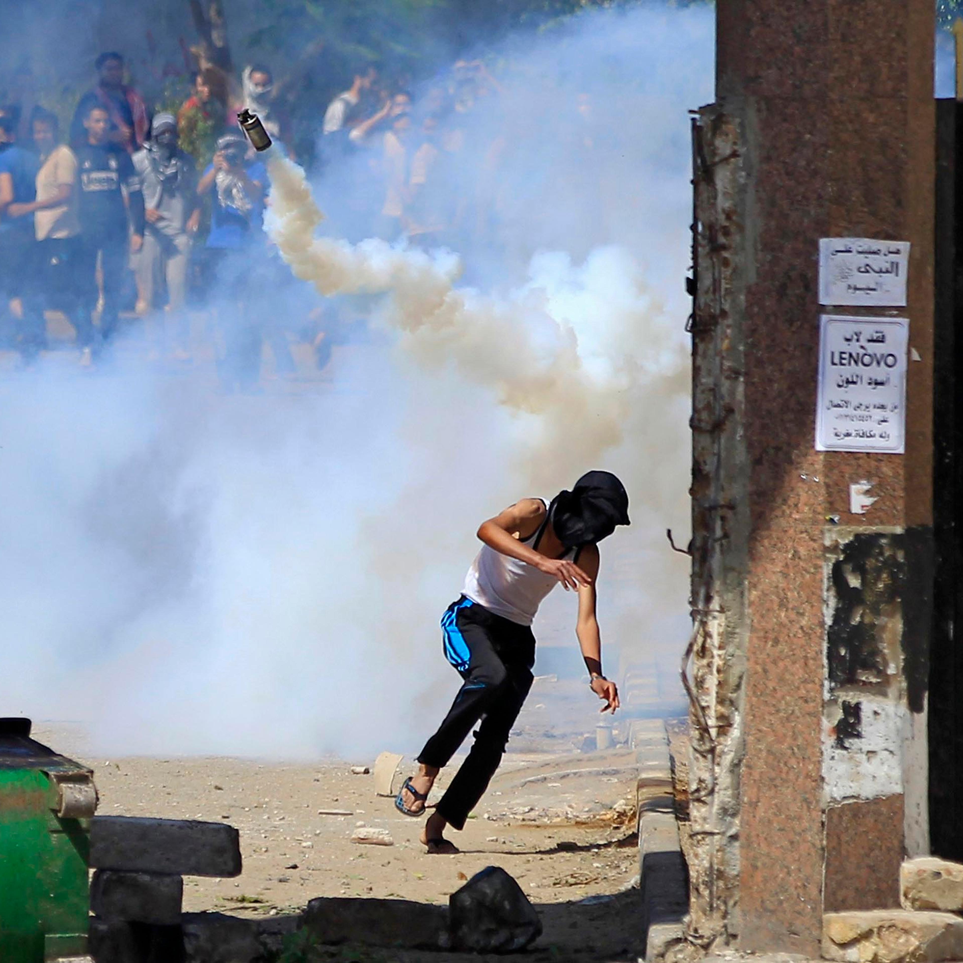 Student supporters of the Muslim Brotherhood and ousted President Mursi flee from tear gas and rubber bullets fired by riot police during clashes at Al-Azhar University's campus, in Cairo