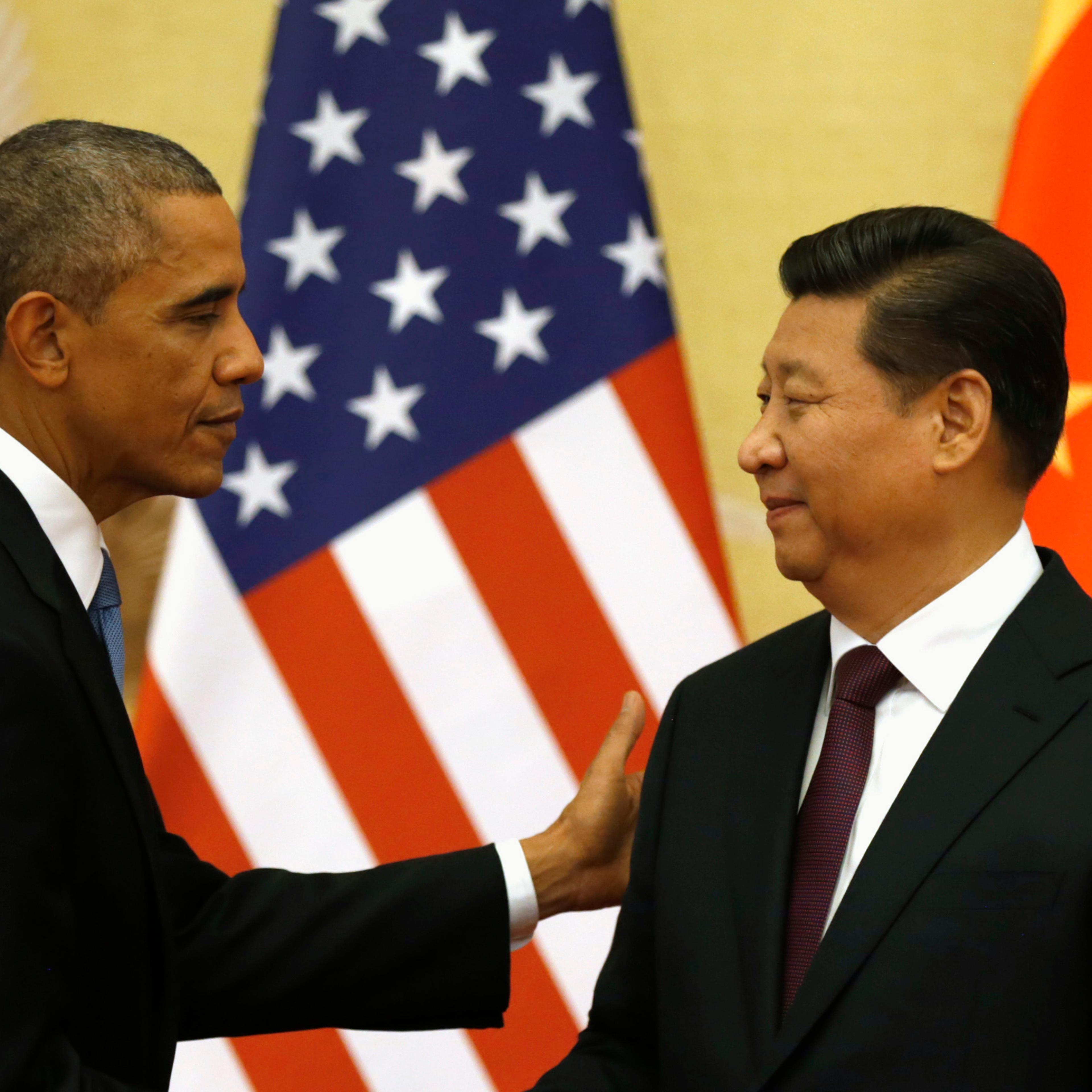 Obama pats Xi on the shoulder at the end of their news conference in the Great Hall of the People in Beijing