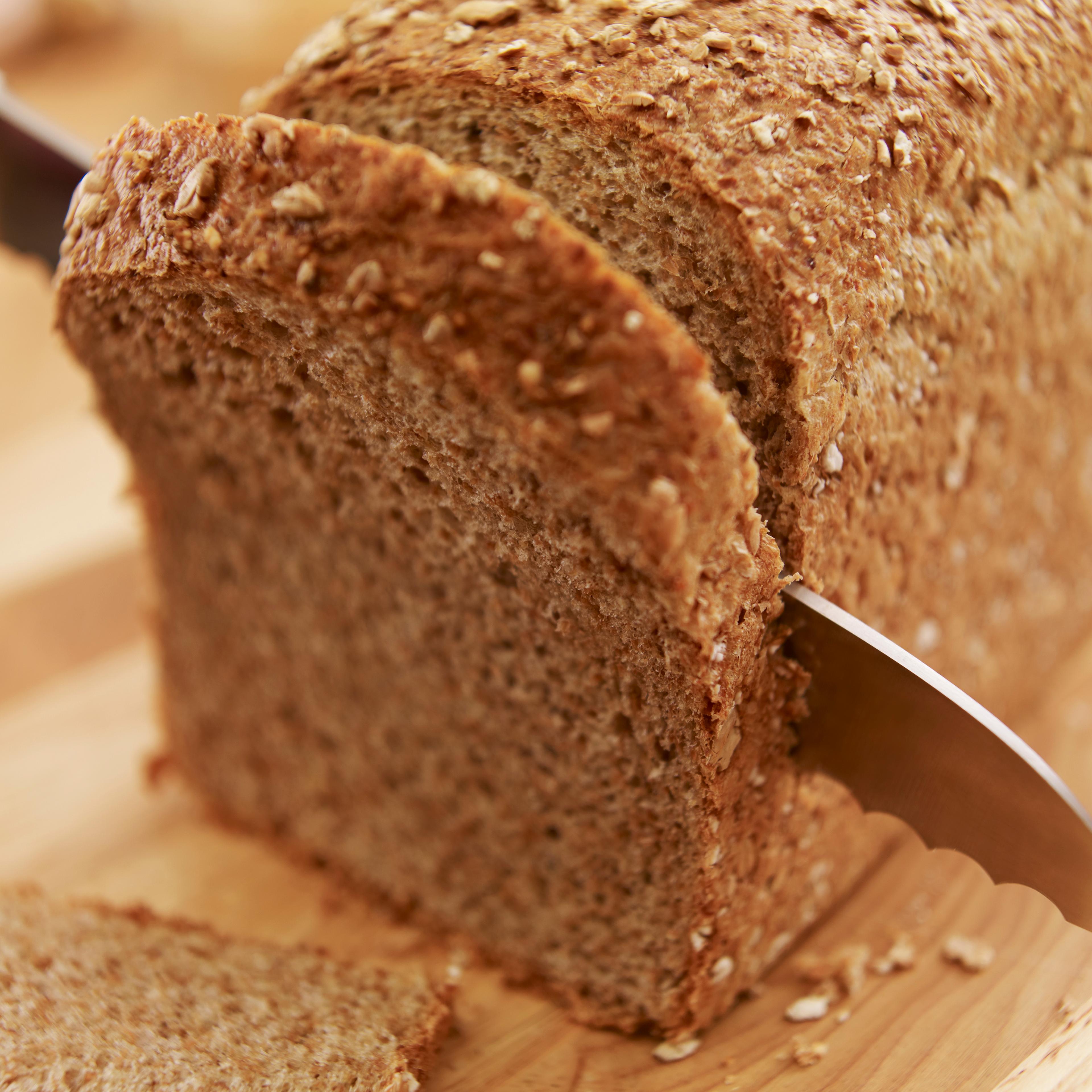 Knife slicing fresh bread loaf