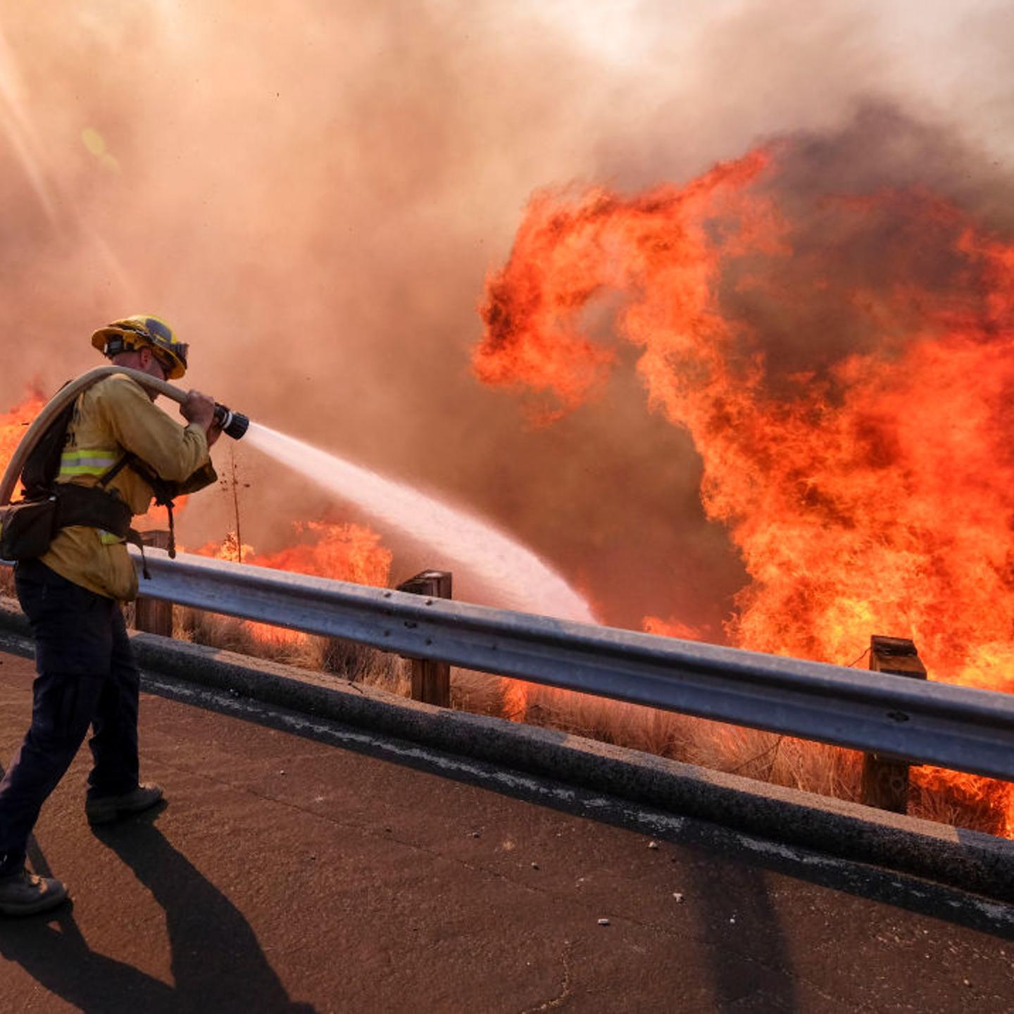 A firefighter battles wildfire near a freeway in Simi Valley, California