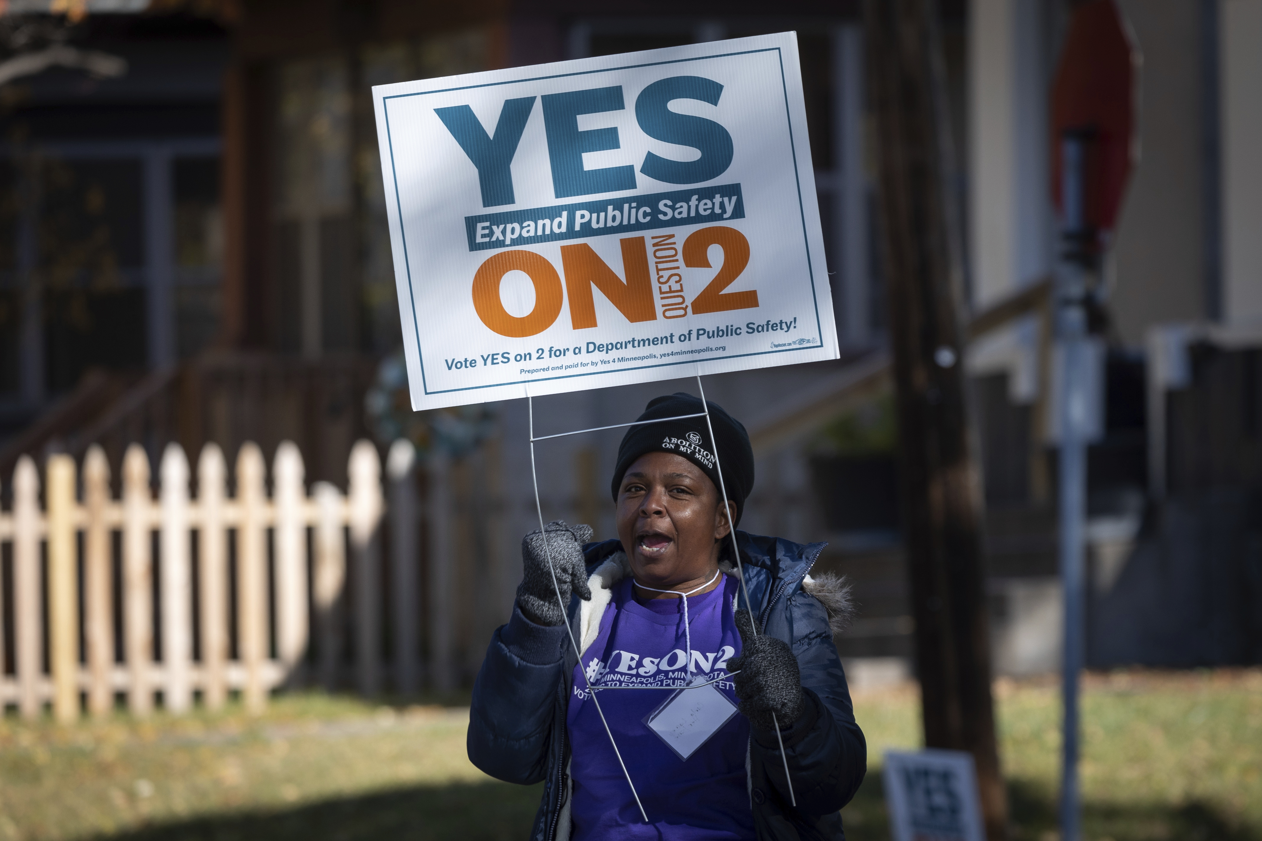 A volunteer urges community members to vote yes on ballot question two outside of a polling place on Tuesday, Nov. 2, 2021 in Minneapolis.