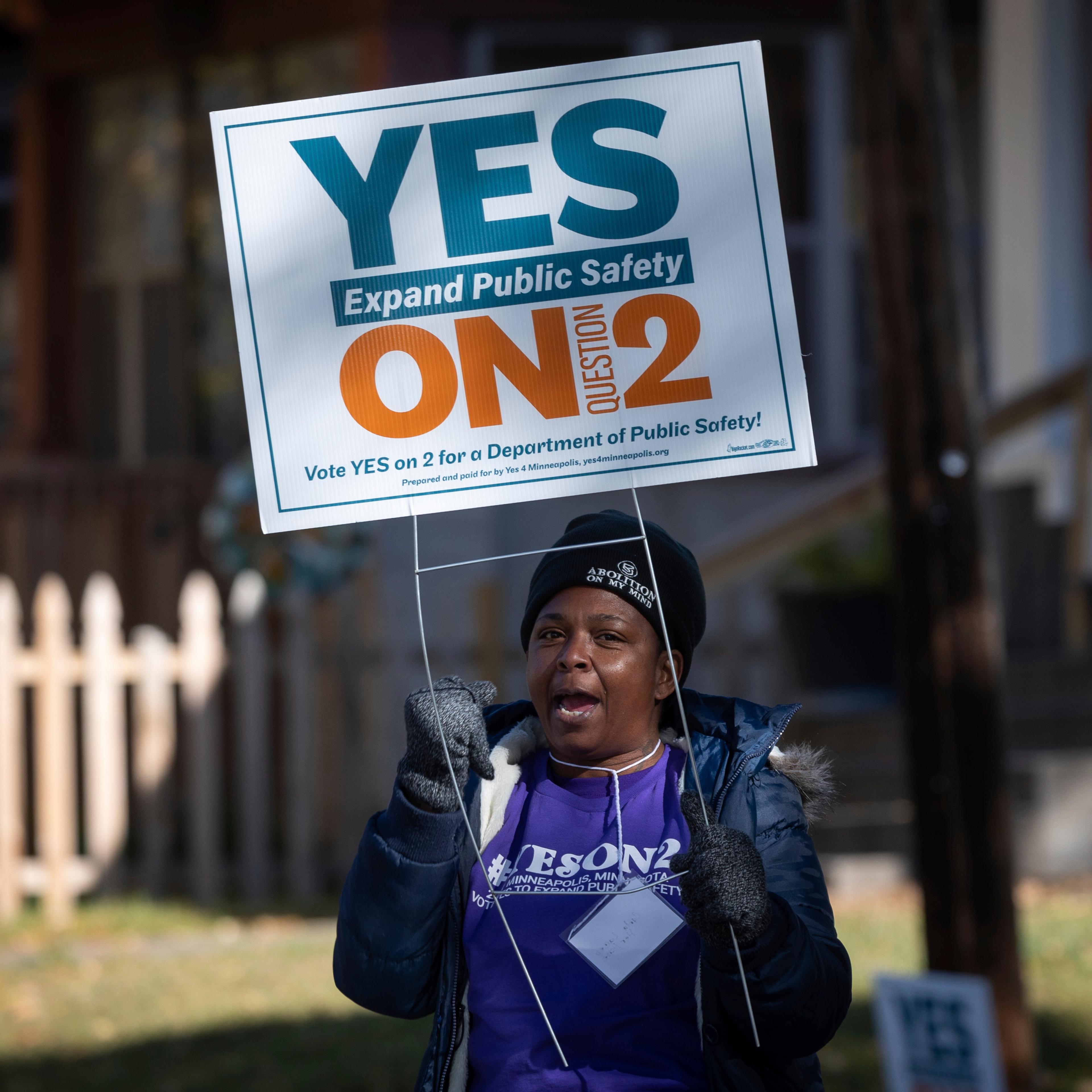 A volunteer urges community members to vote yes on ballot question two outside of a polling place on Tuesday, Nov. 2, 2021 in Minneapolis.