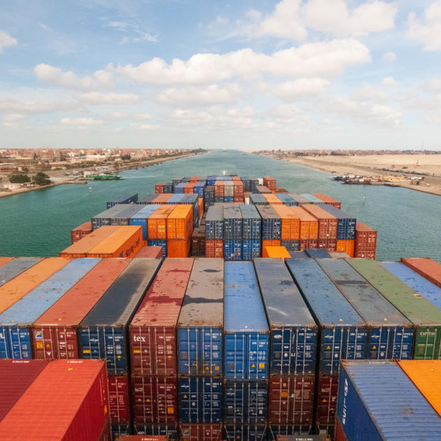 Loaded containers stacked on top of a cargo ship sailing in a canal, Suez Canal, Red sea, Egypt