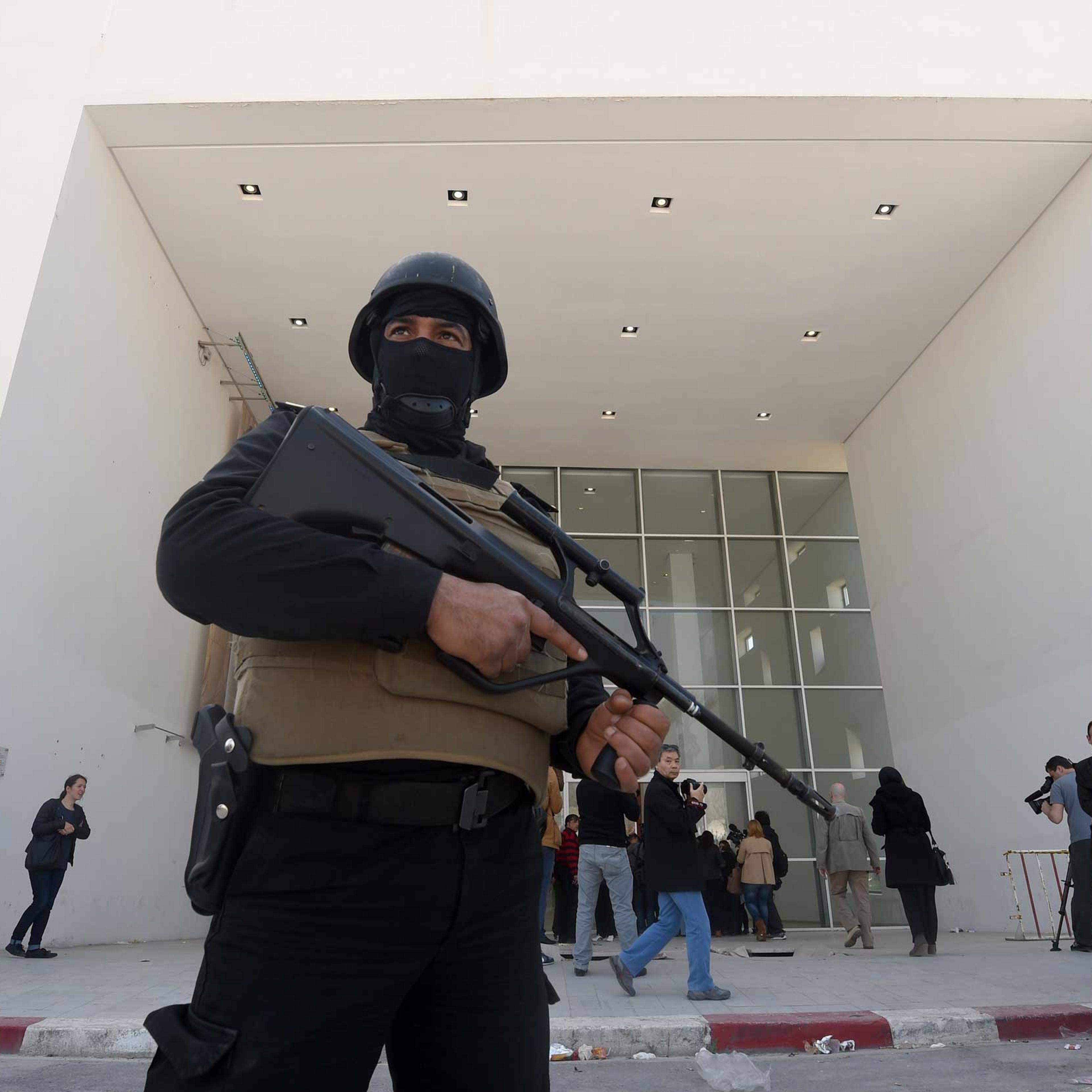 A member of the Tunisian security forces stands guard as journalists gather at the visitors entrance of the National Bardo Museum in Tunis on March 19, 2015.