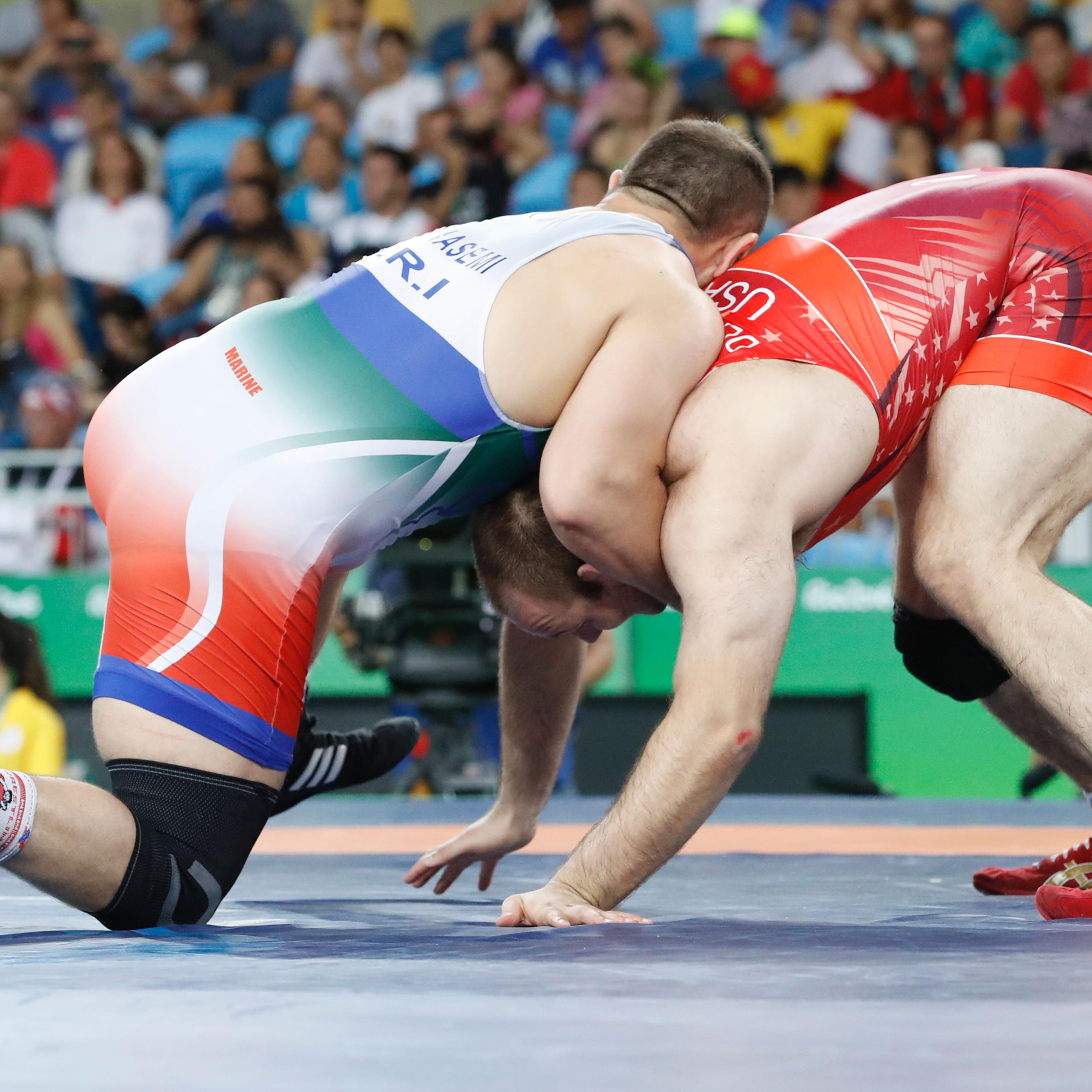 Iran's Komeil Nemat Ghasemi (blue) wrestles with USA's Tervel Ivaylov Dlagnev in their men's 125kg freestyle semi-final match on August 20, 2016, during the wrestling event of the Rio 2016 Olympic Games at the Carioca Arena 2 in Rio de Janeiro. / AFP / J